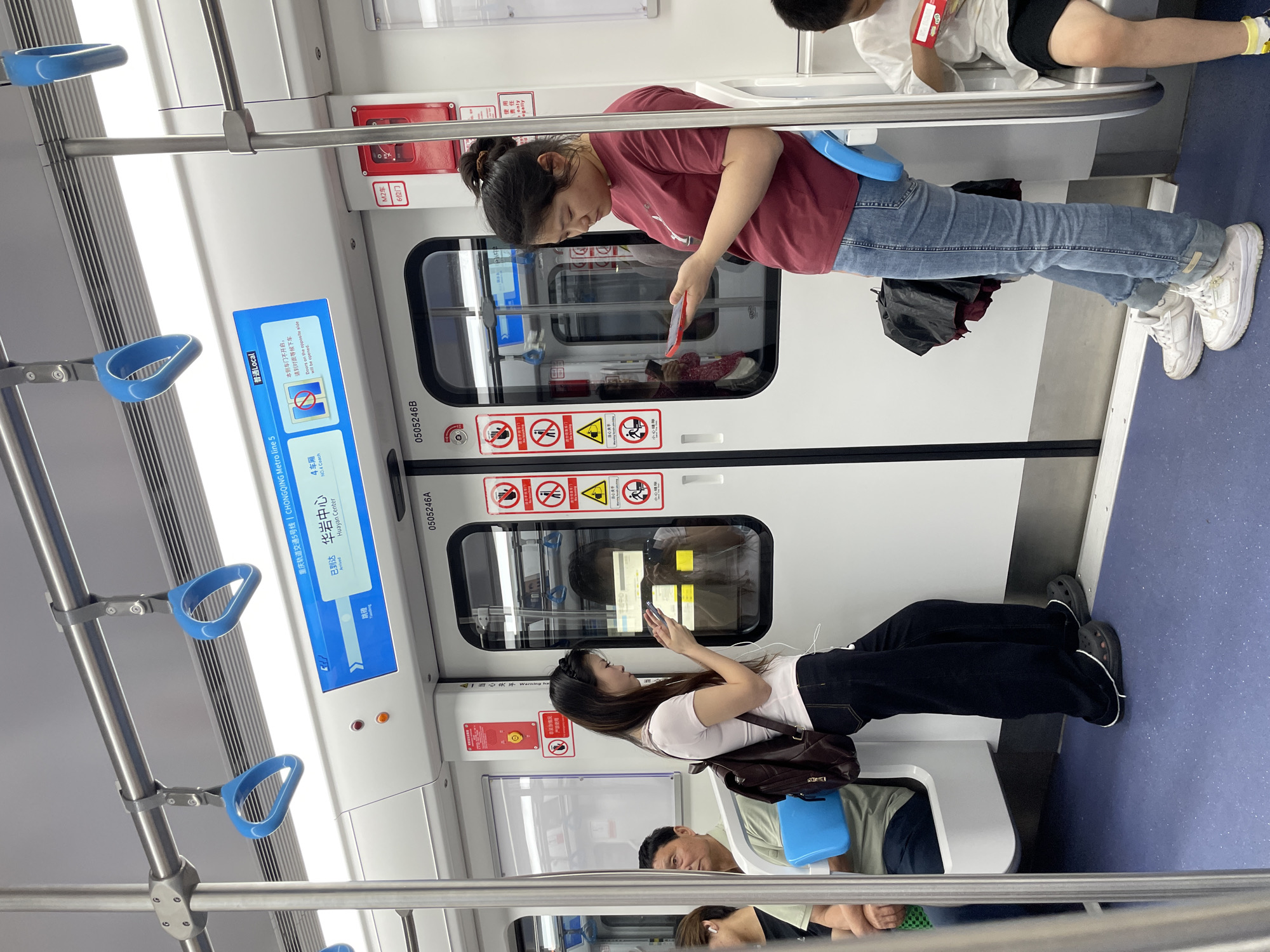 Woman uses phone on subway in Jiulongpo District