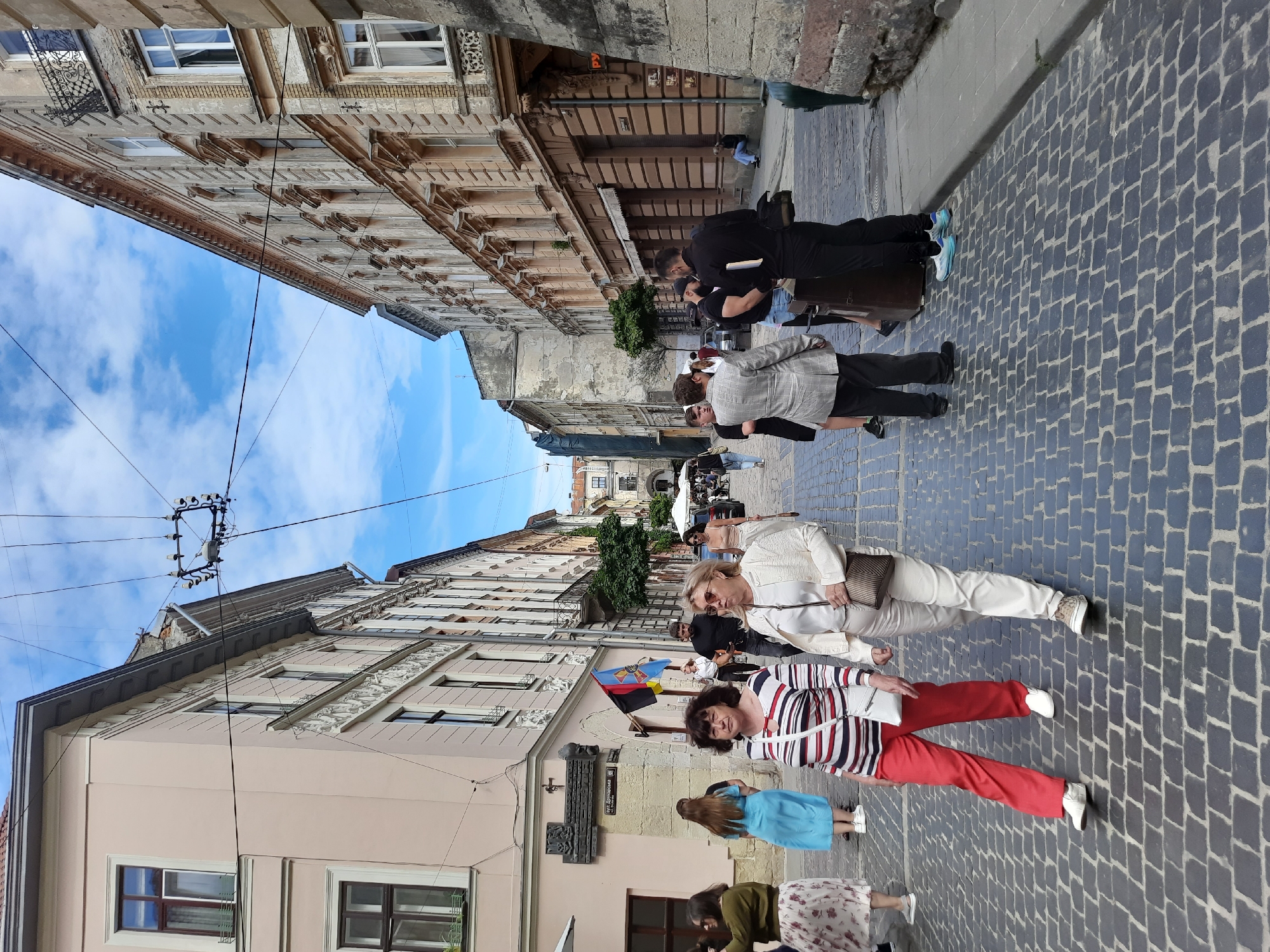 Afternoon street life near a Lviv church and café
