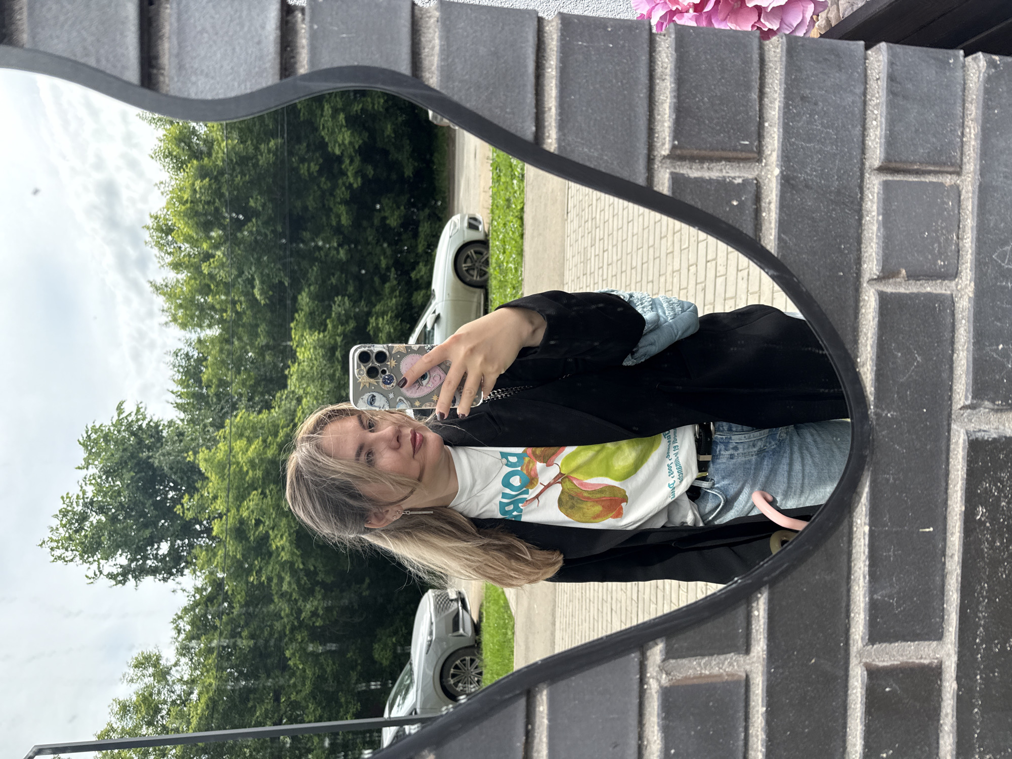 Woman takes mirror selfie with eye-patterned phone case