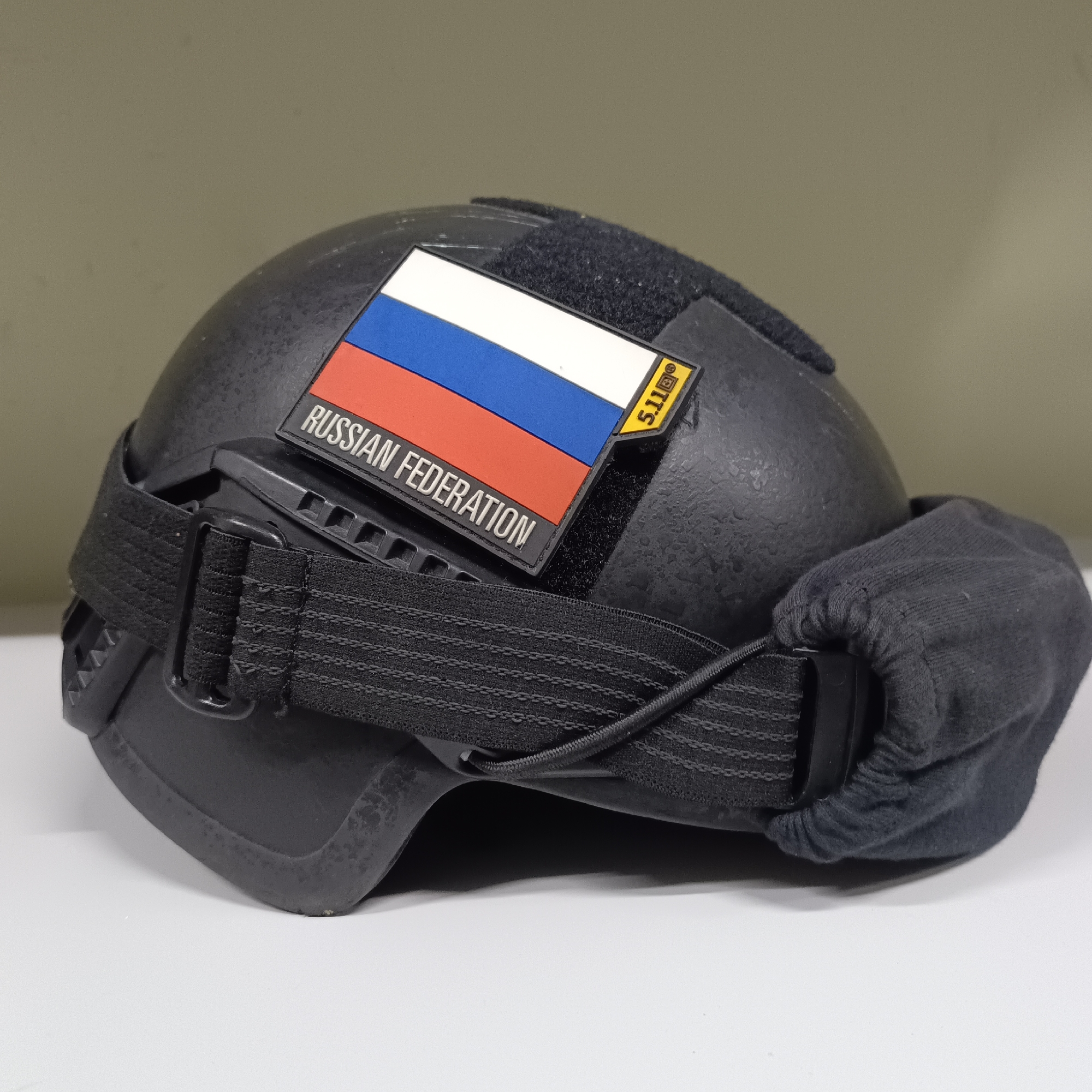 Two tactical helmets with military patches displayed up close