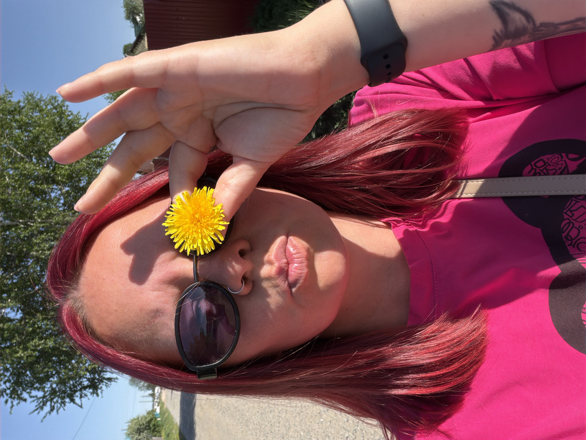 Red-haired person photographs wildflowers in Chaikovsky forest setting