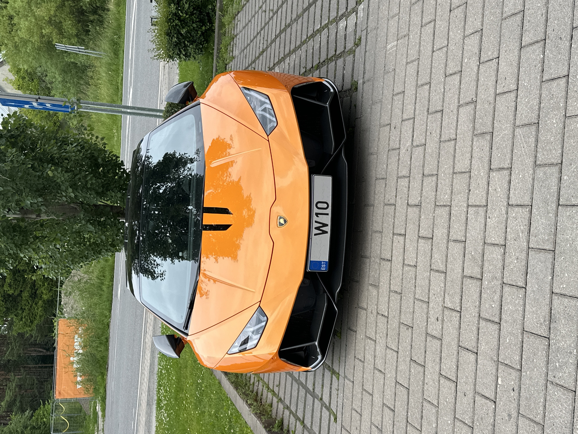 Orange Lamborghini Huracán parked on pavers in Tallinn