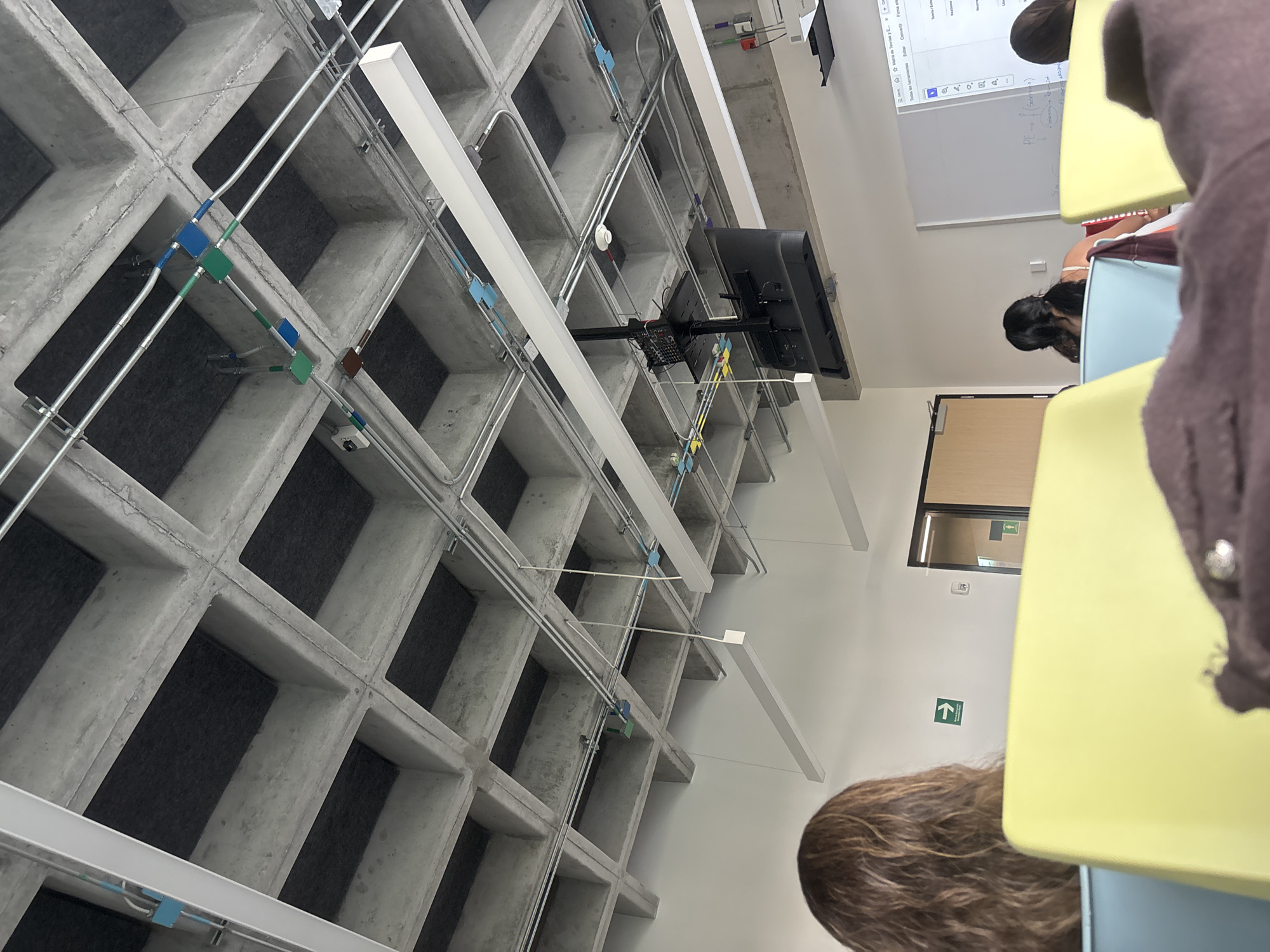 Students gather in modern industrial-style classroom with concrete ceilings