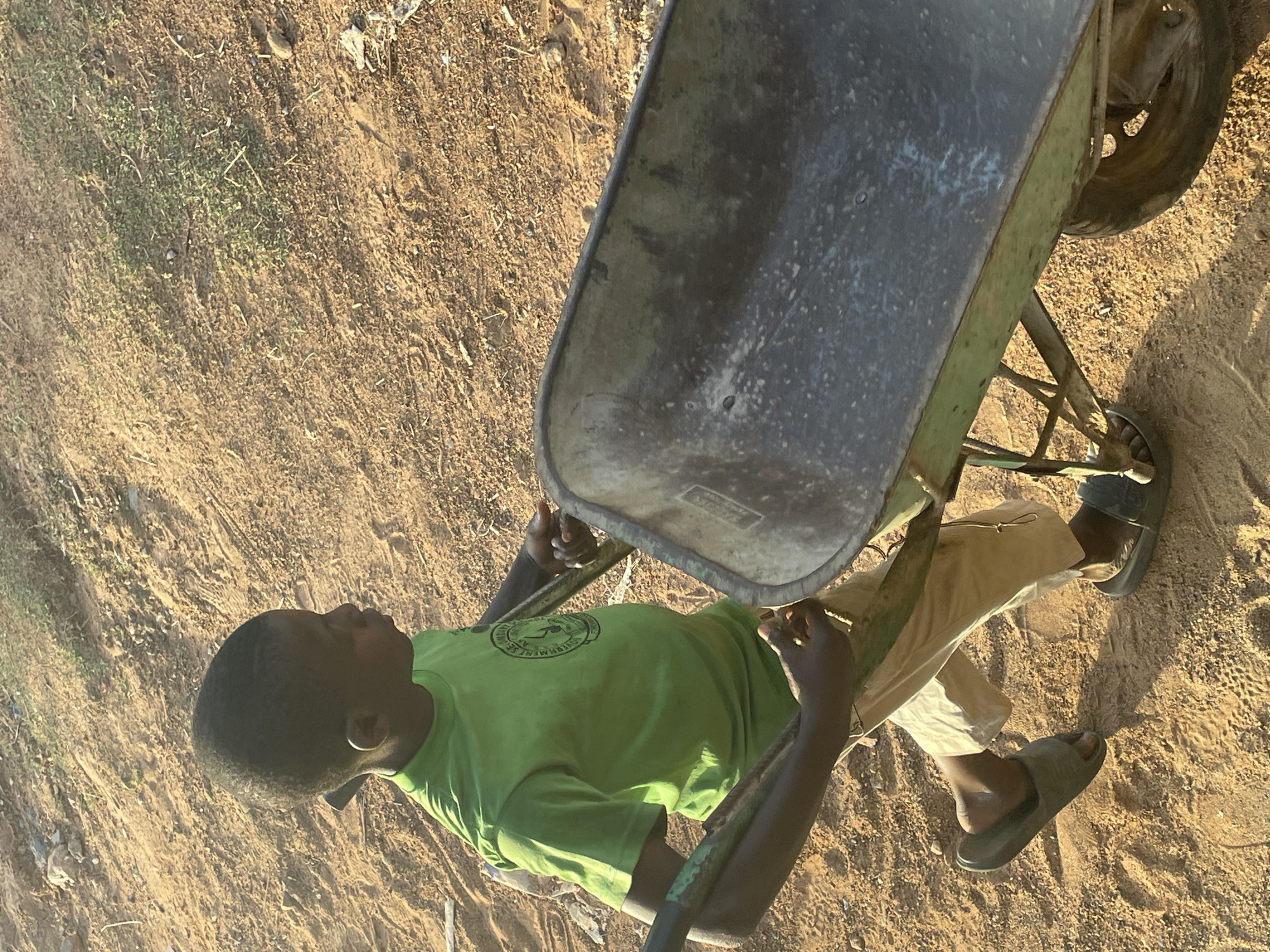 People engage in outdoor activities on dirt field in Akwanga