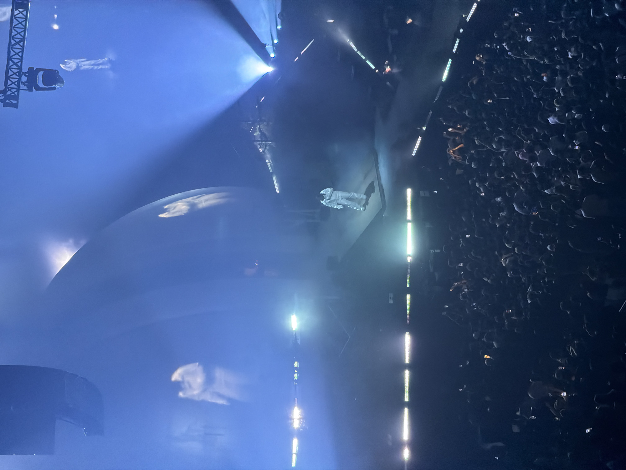 White-suited performer takes stage amid blue lights in Montreal concert