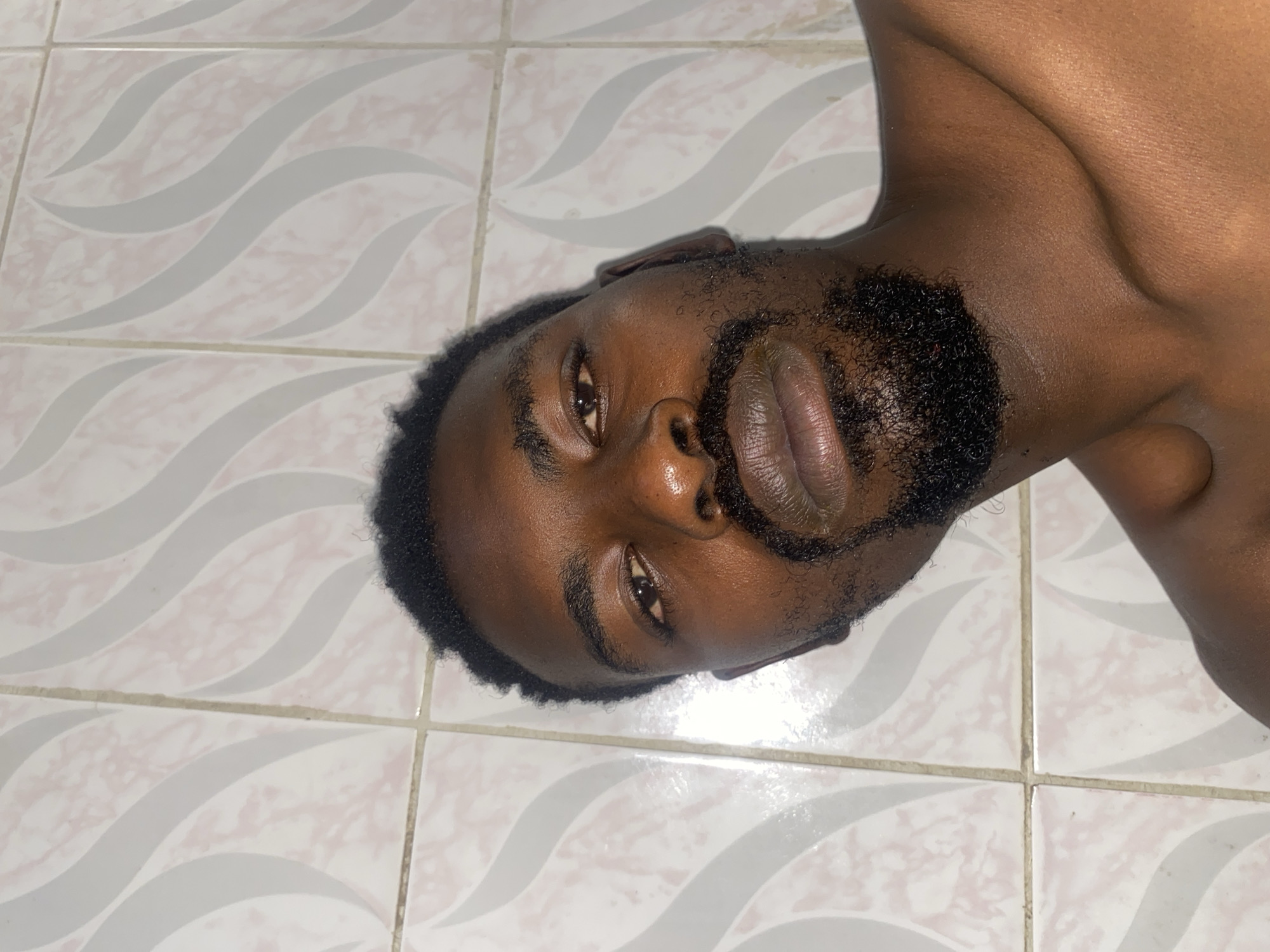 Man lying on tiled floor in Barakin Akawo, Nigeria