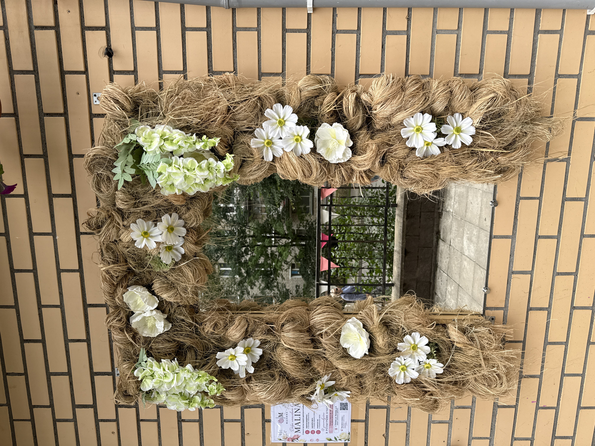 Twine archway with mirror and flowers on a Gatchina street