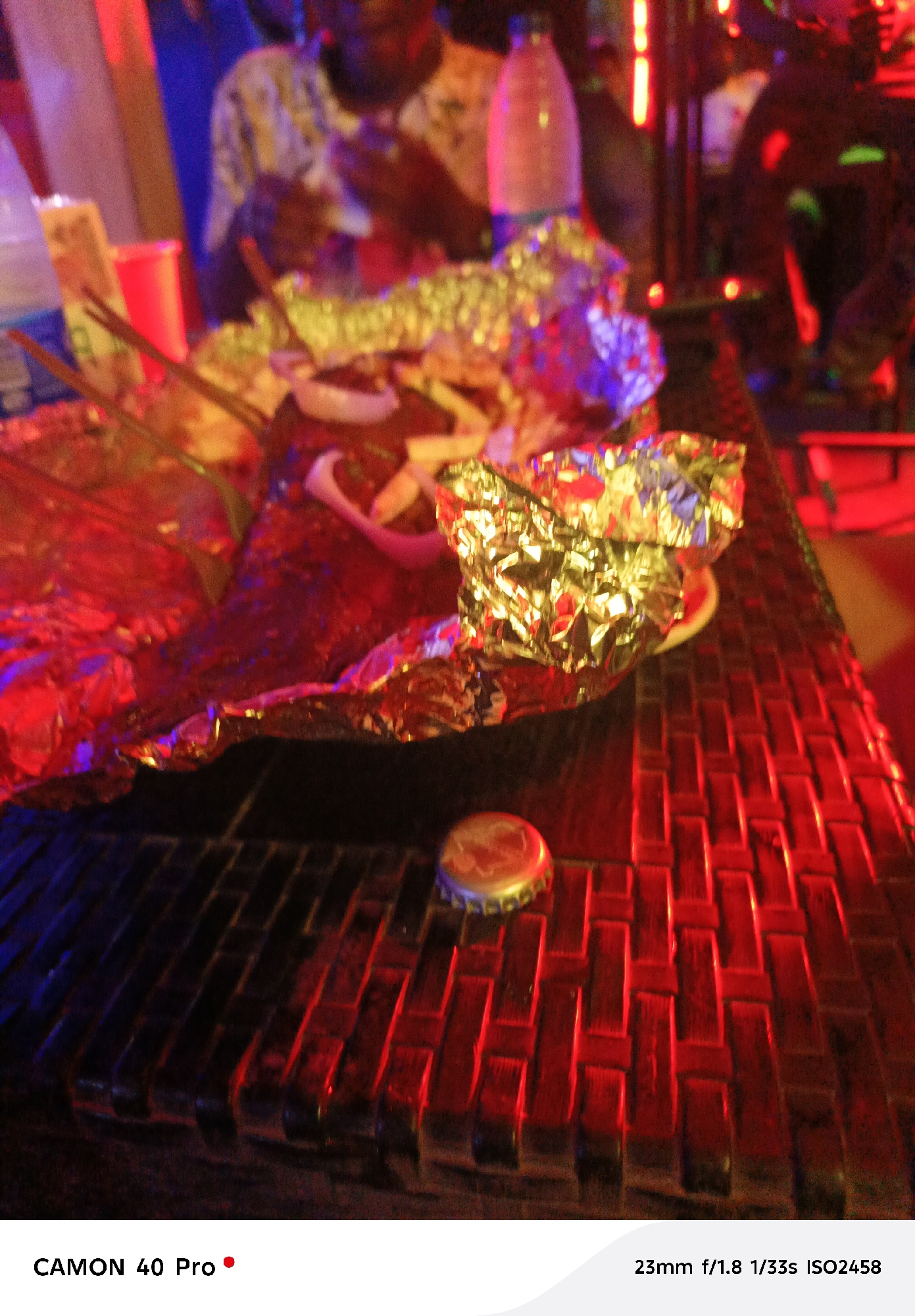 Indoor gathering documented by witnesses with food, red lighting