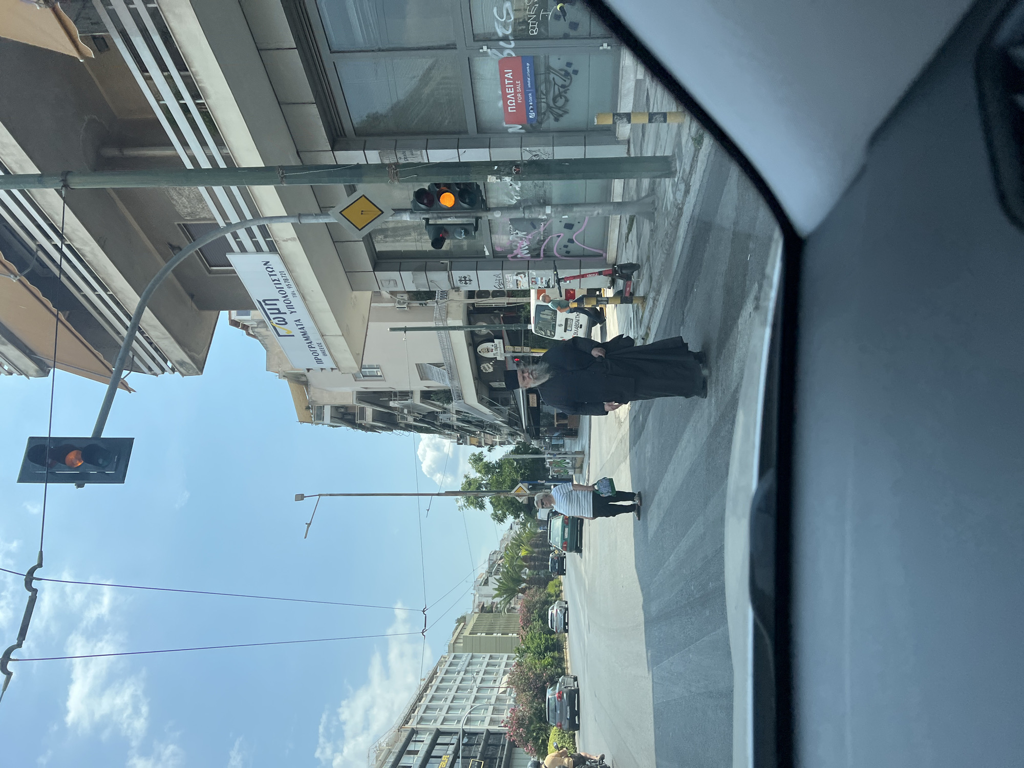 Orthodox clergy crossing a Kallithea street on a sunny morning