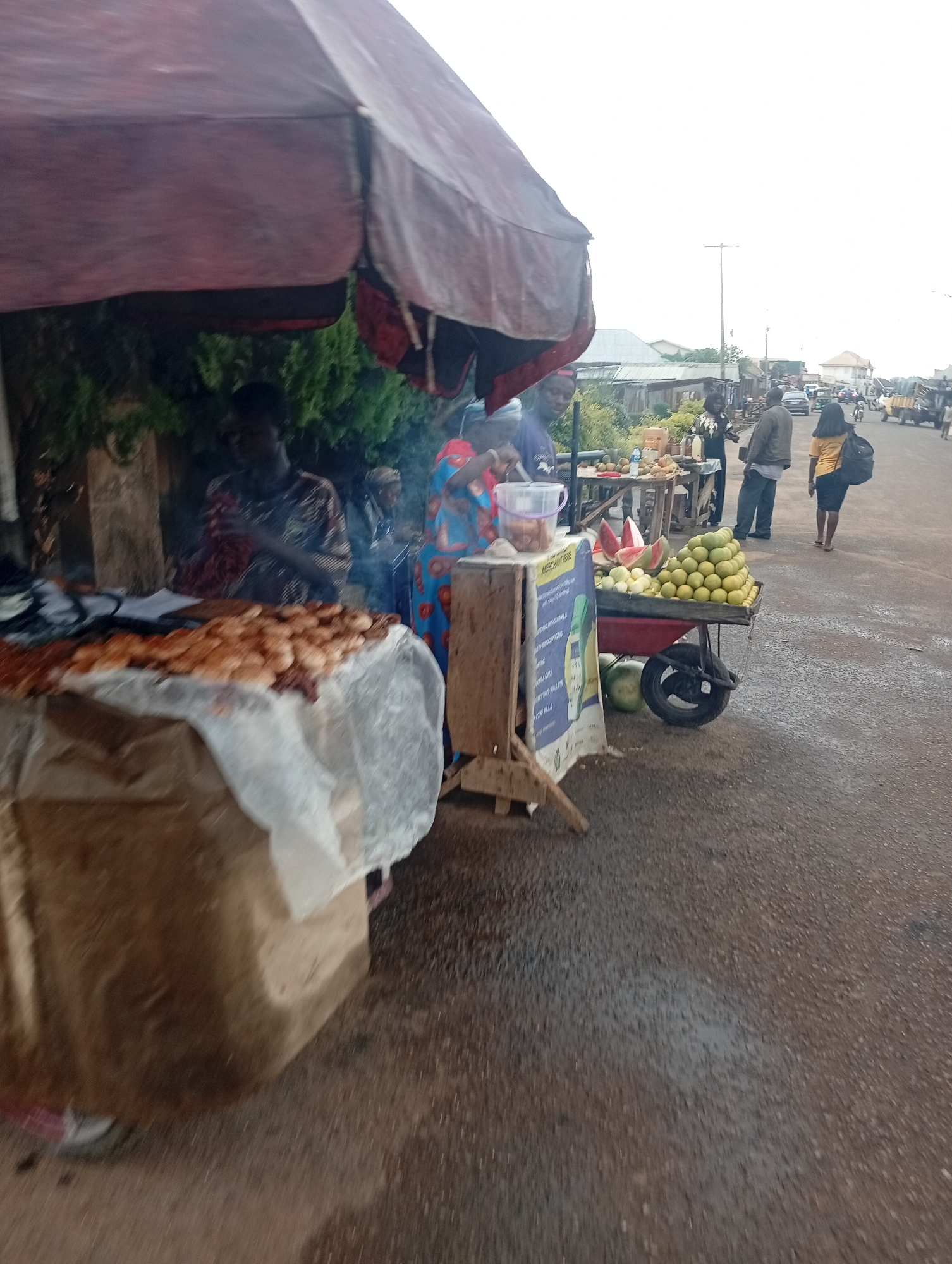 Street vendors and auto-rickshaw captured in Jos market scene