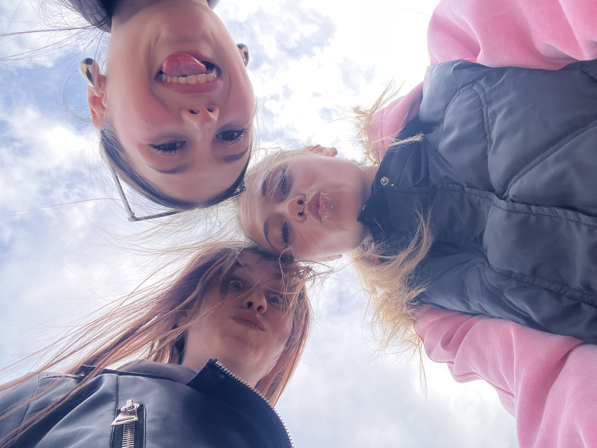 Three women photograph themselves under dramatic skies in rural Russia