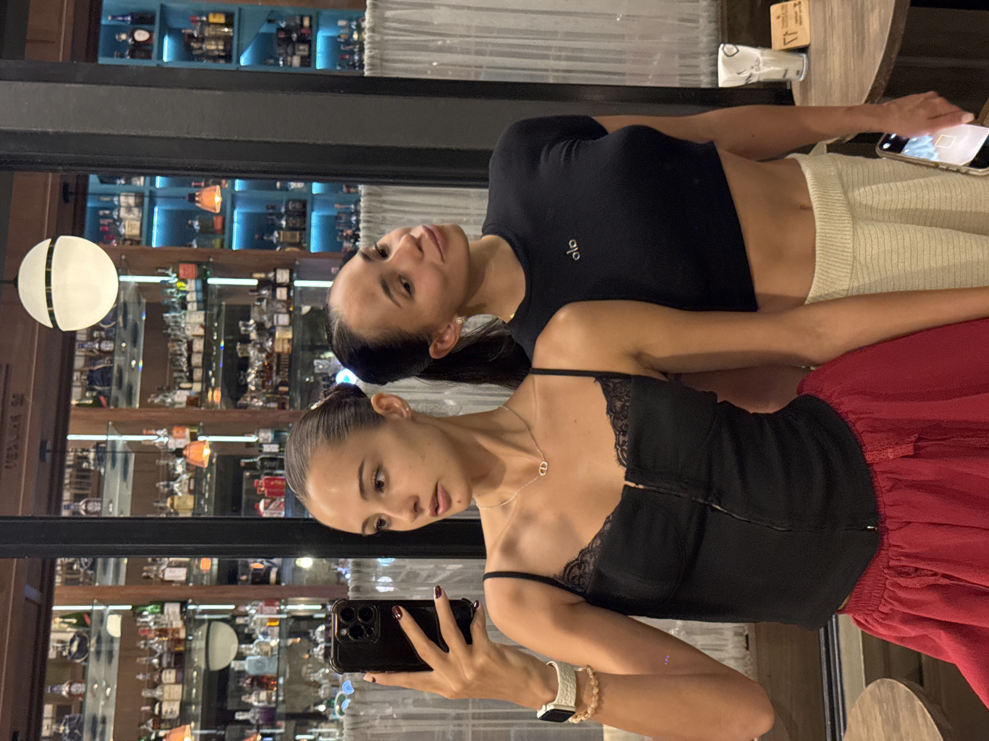 Two women take selfies at upscale Phuket bar