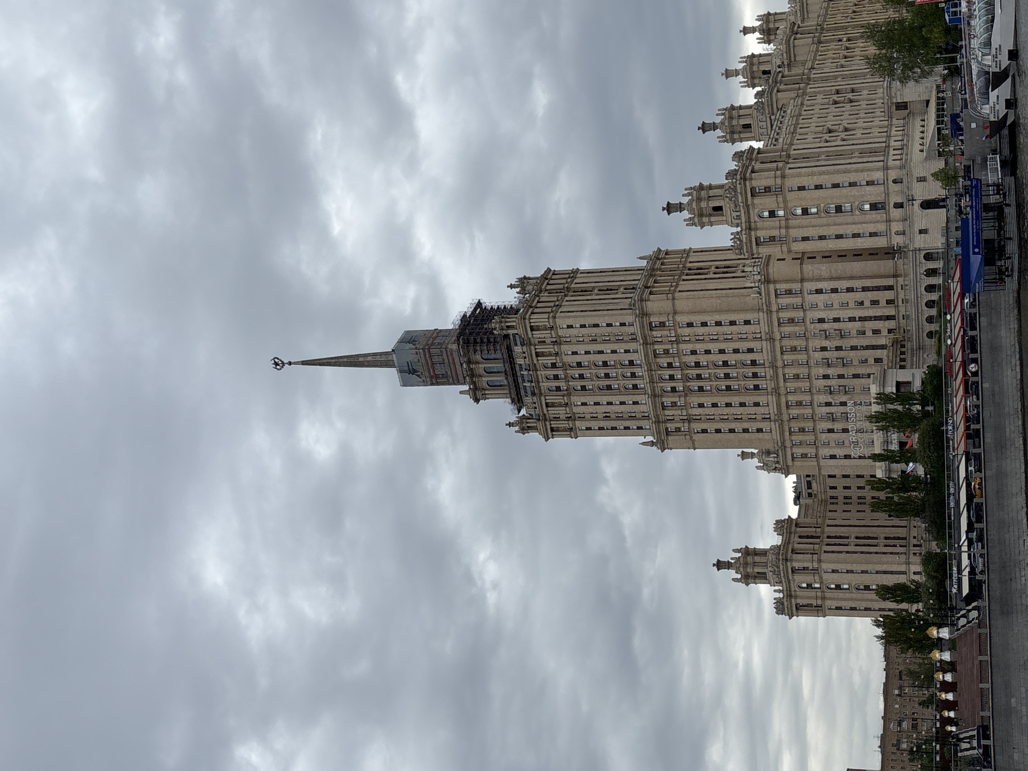 Tourist photographs Moscow State University building during midday visit