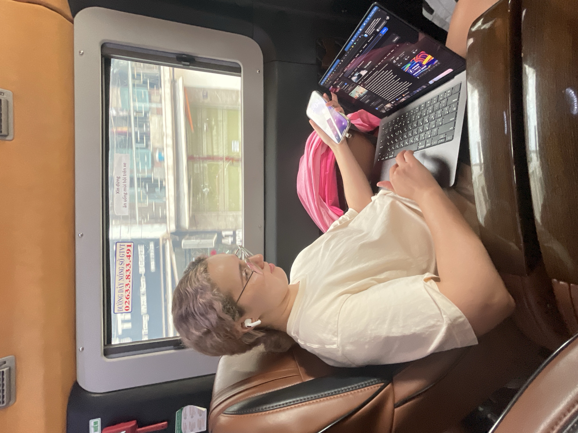 Woman with purple hair uses phone in Nha Trang vehicle