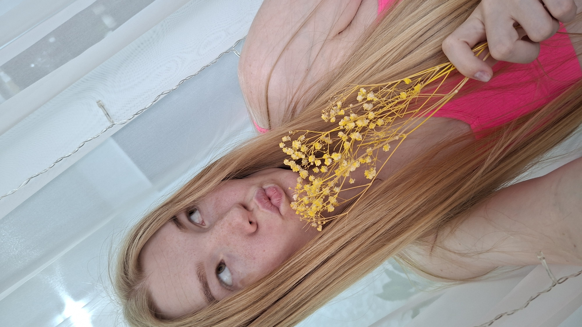 Woman poses with yellow flowers indoors in Chaikovsky, Russia