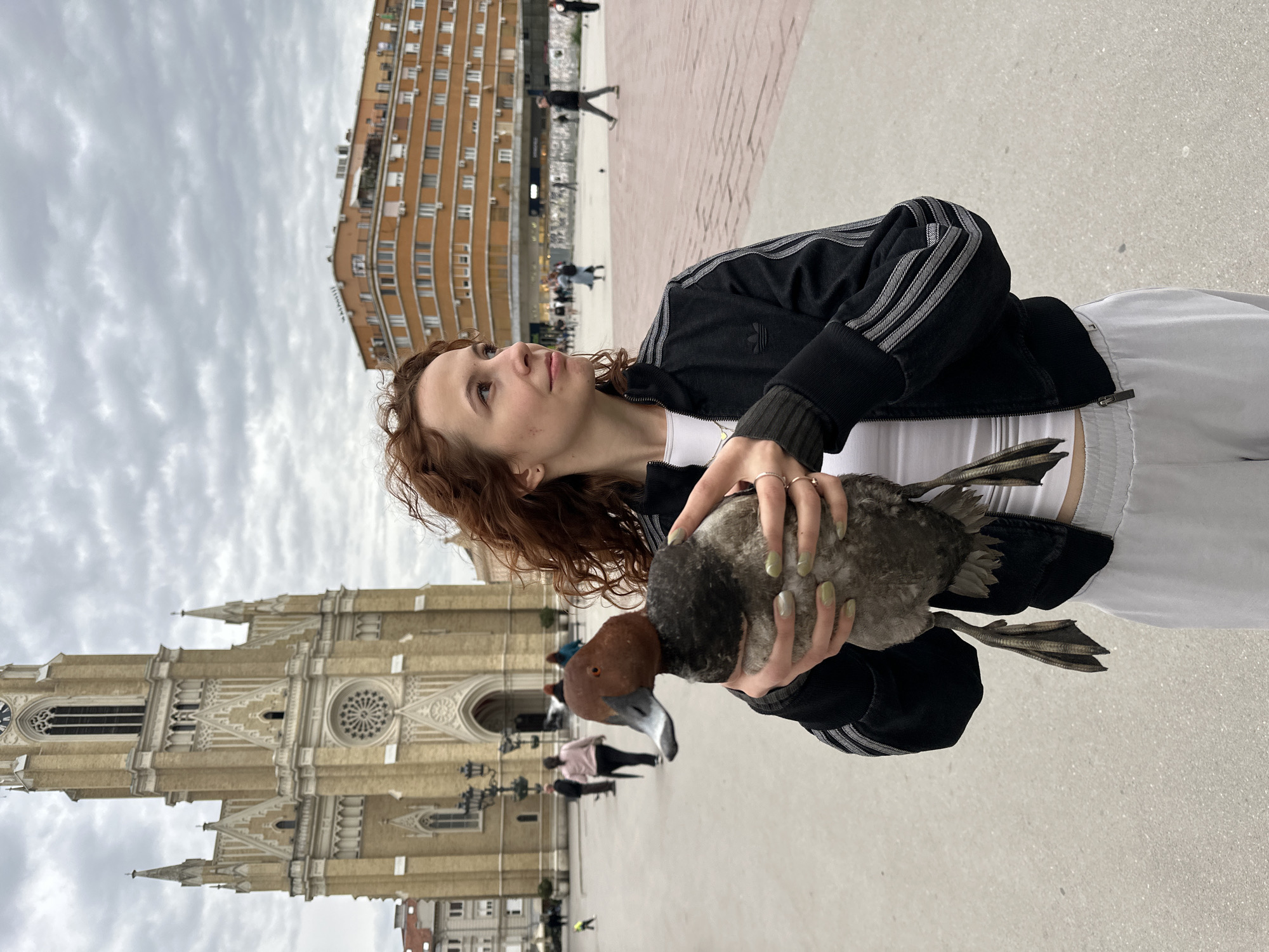 Woman holds duck in Novi Sad public square