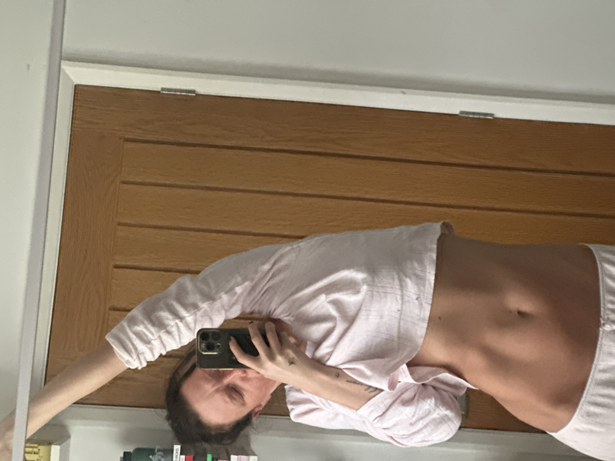 Woman takes mirror selfie in pink pajamas, Wealden UK