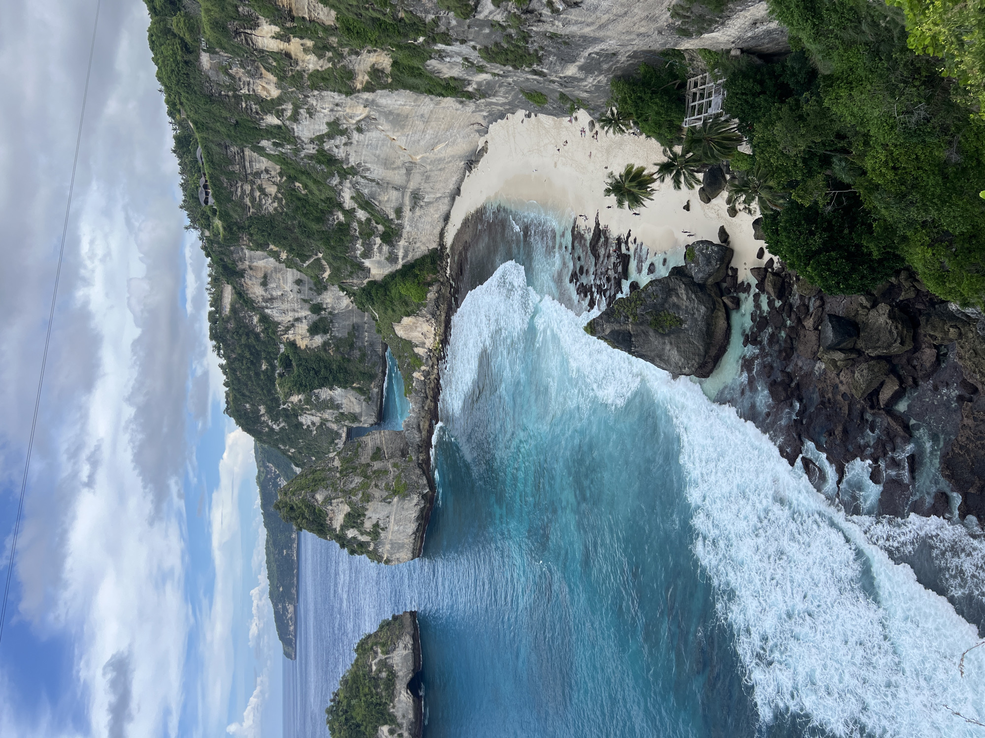 Early morning tourists gather at Nusa Penida's Diamond Beach cliffs