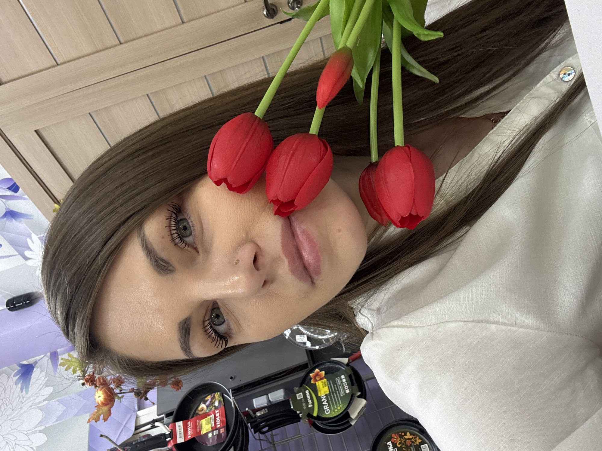 Woman photographs herself with flower bouquets in Klin store