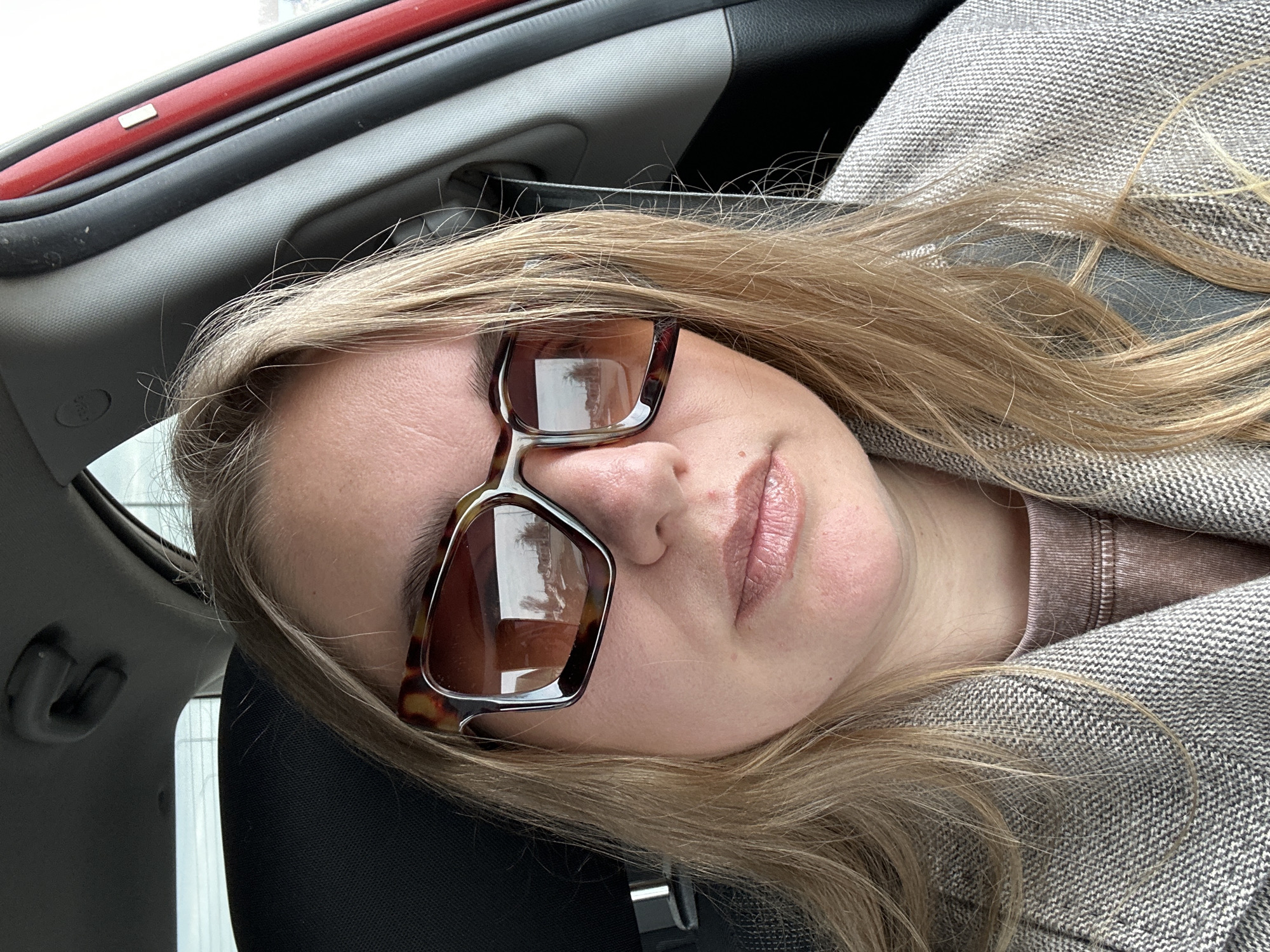 Woman in sunglasses sits in car in Russia