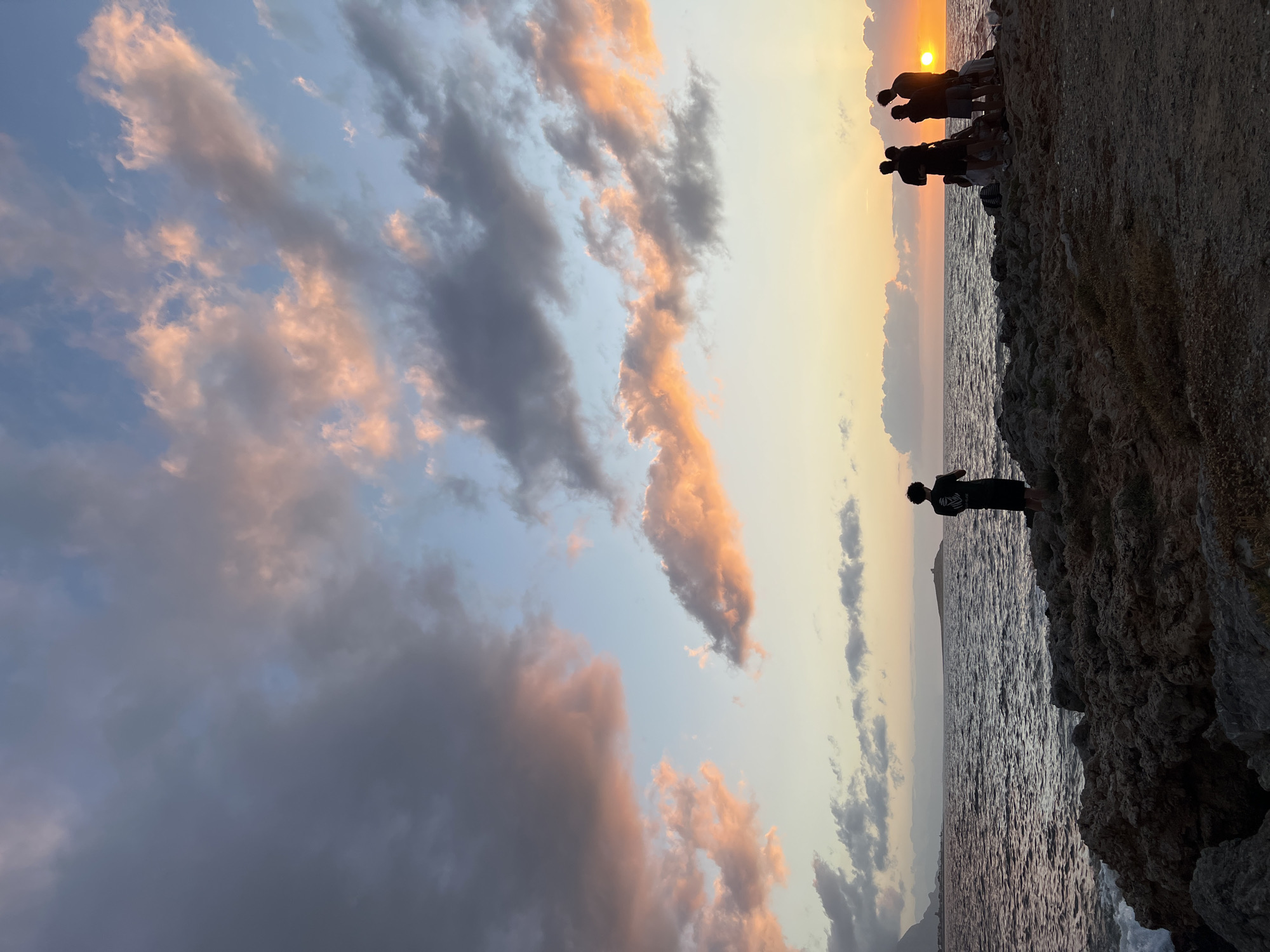 Young people watch sunset from Palermo rocky coastline