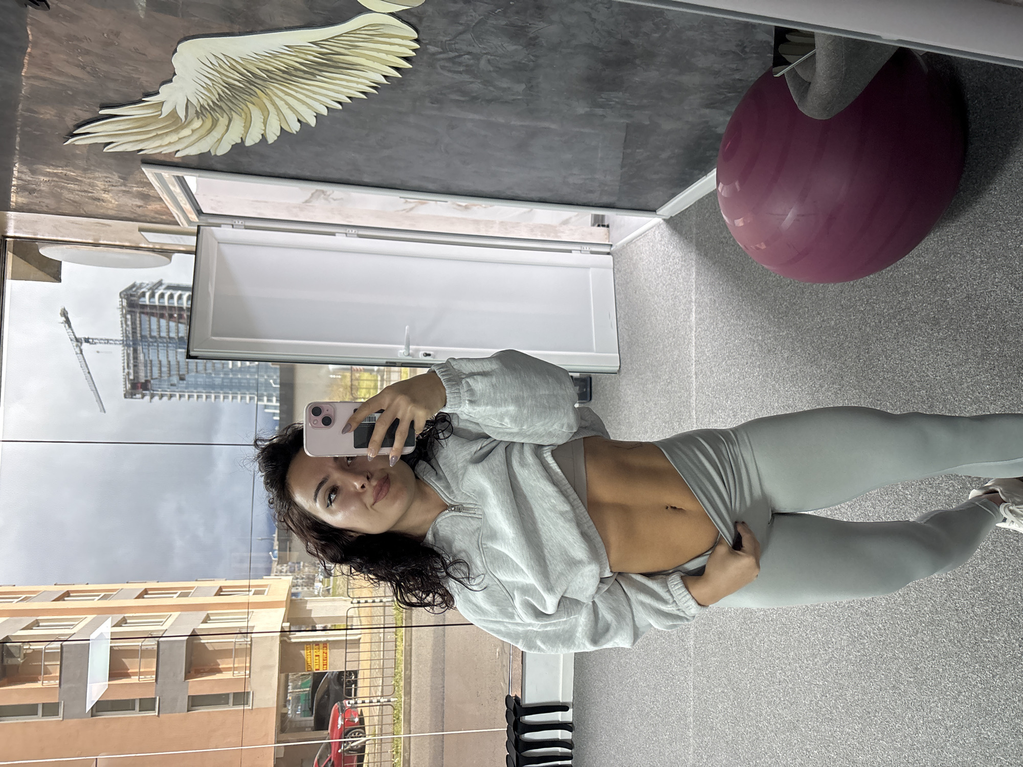 Woman takes selfie with urban cityscape window reflection
