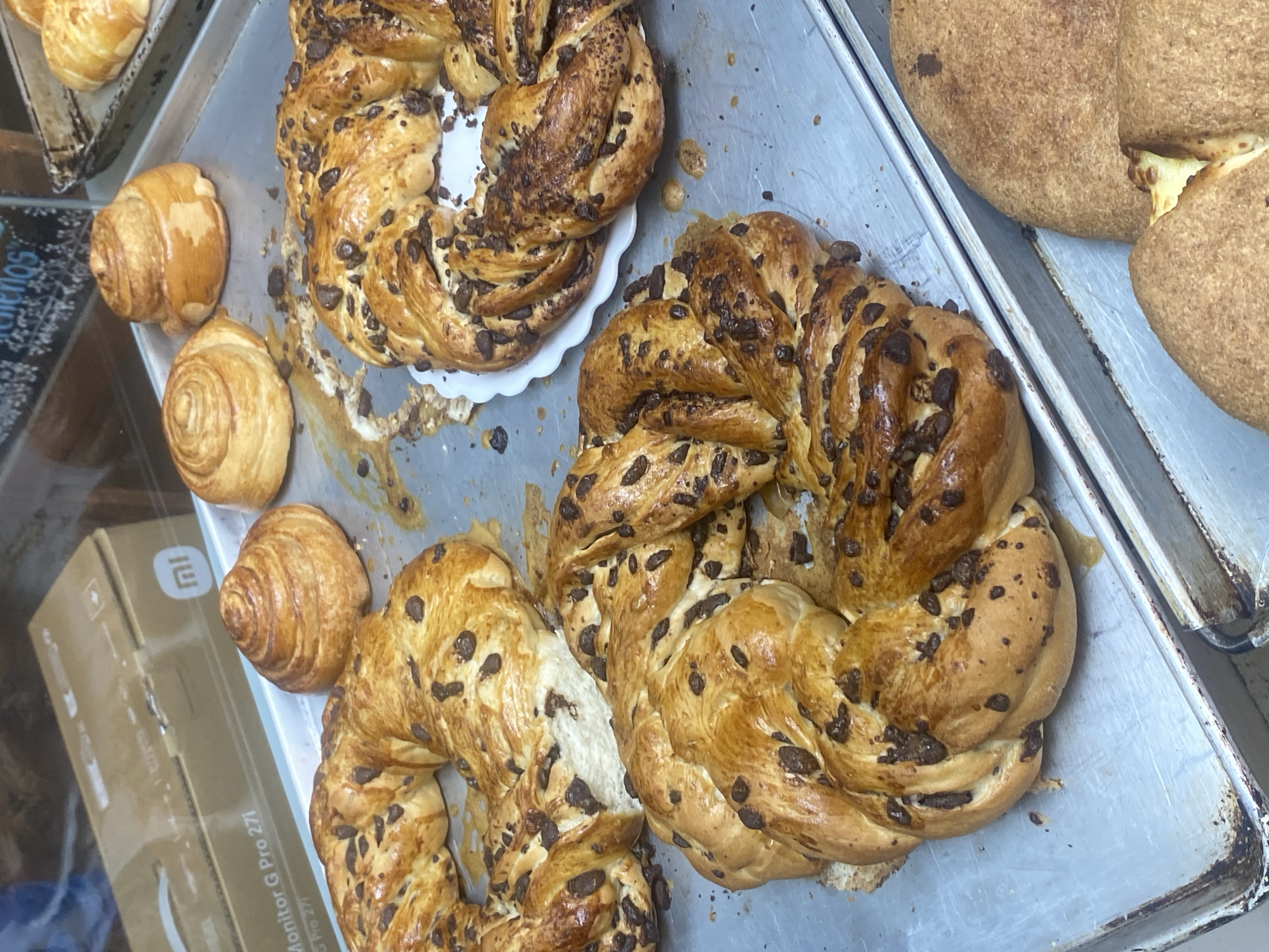 Bakery worker arranges fresh pastries in La Paz display
