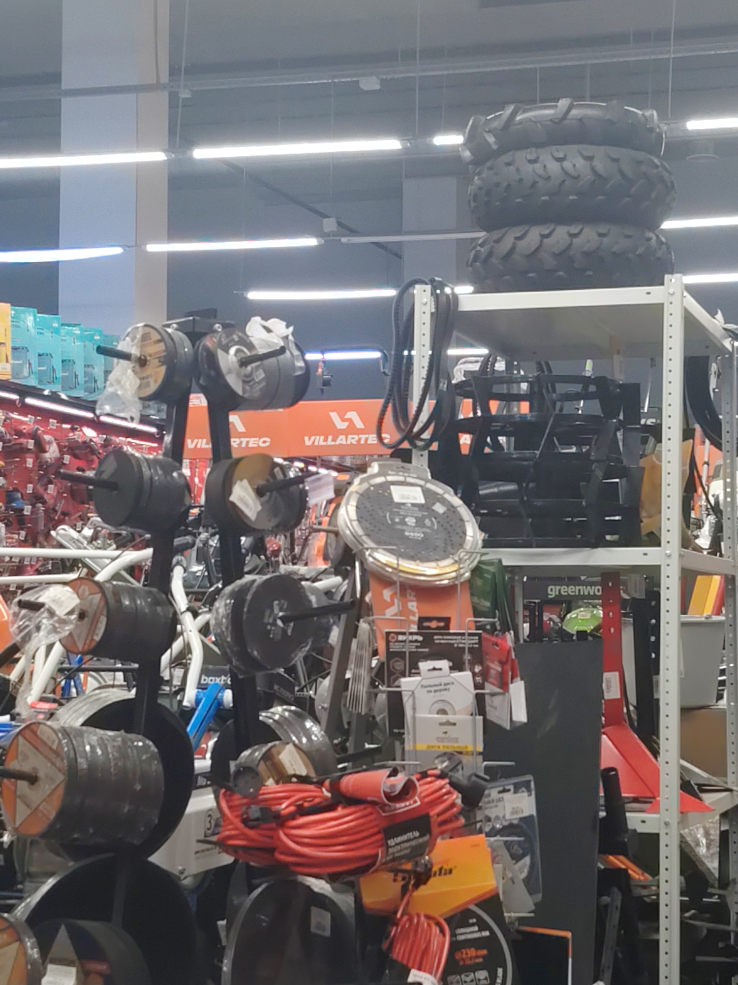 Hardware store floor packed with outdoor power equipment and electric vehicles