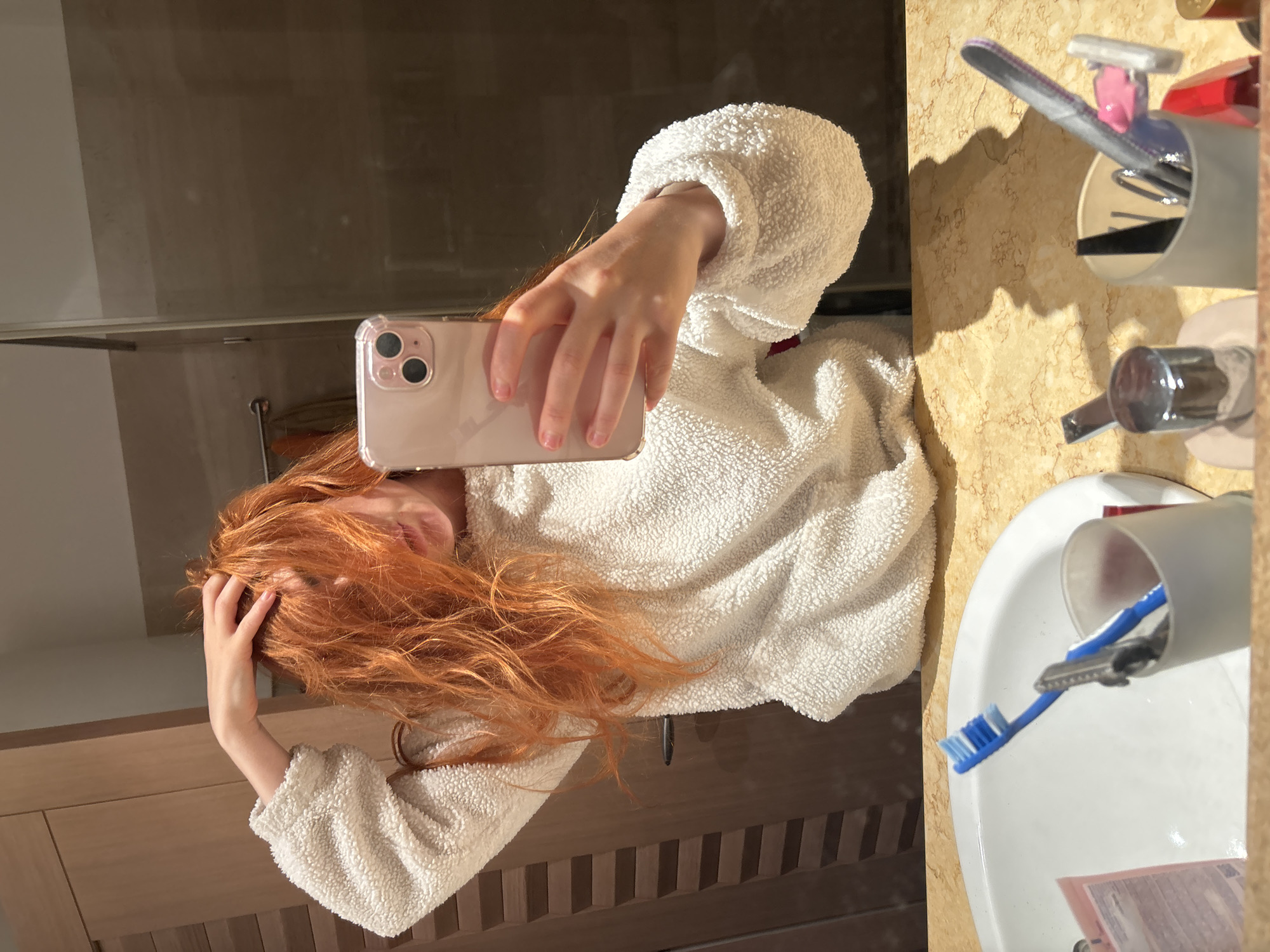 Woman multitasks with phone during bathroom routine in Budva
