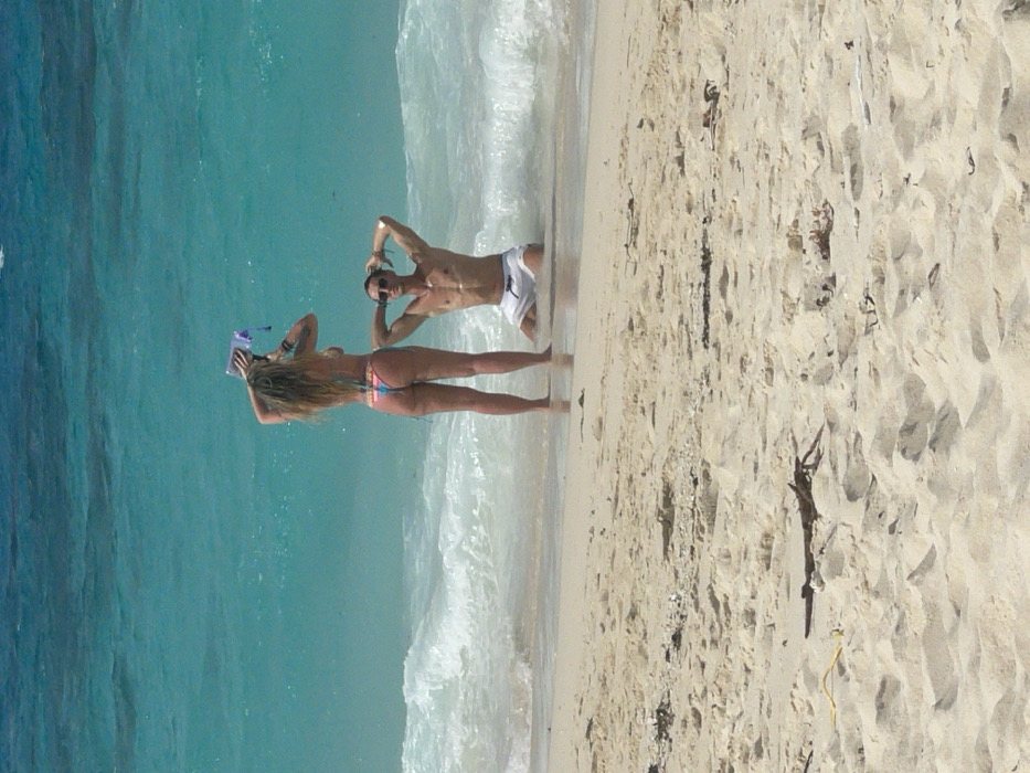 Beach day captured at Zanzibar shoreline with swimmers and sunbathers