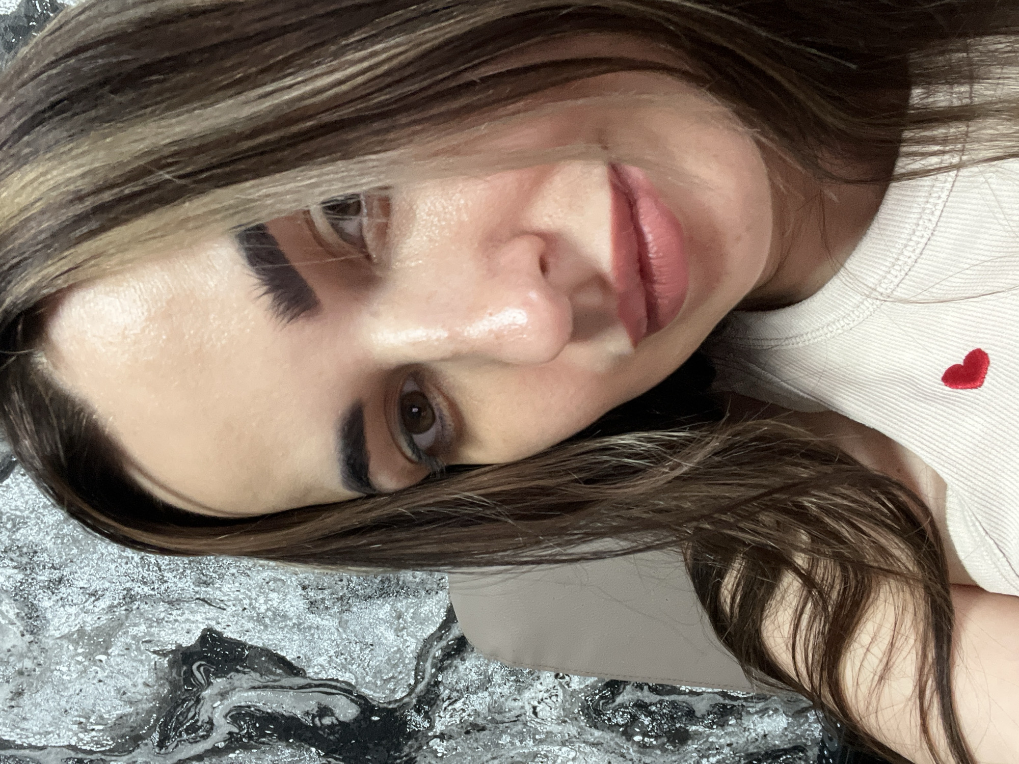 Woman takes multiple selfies during morning indoor photo session