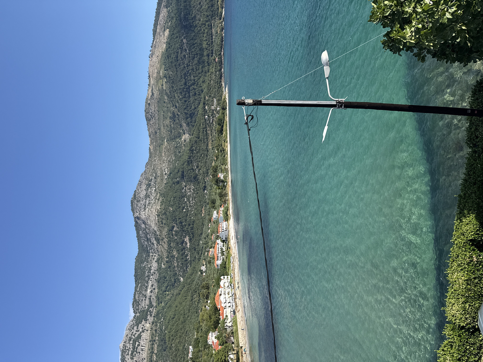 Rocky swim spot on Thassos coast, turquoise water, bright summer morning