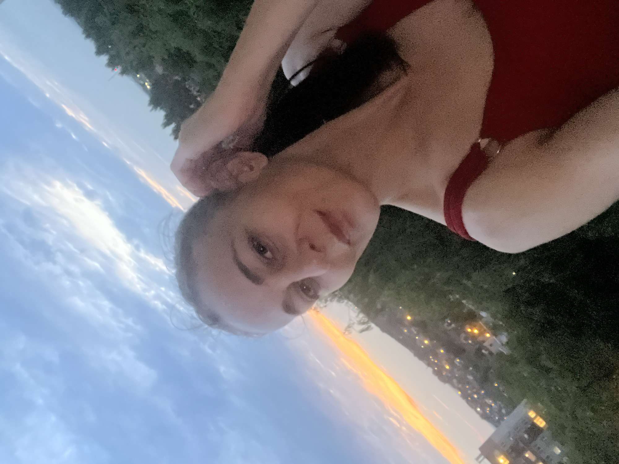 Rooftop-level sunset selfie session over a city skyline at dusk.