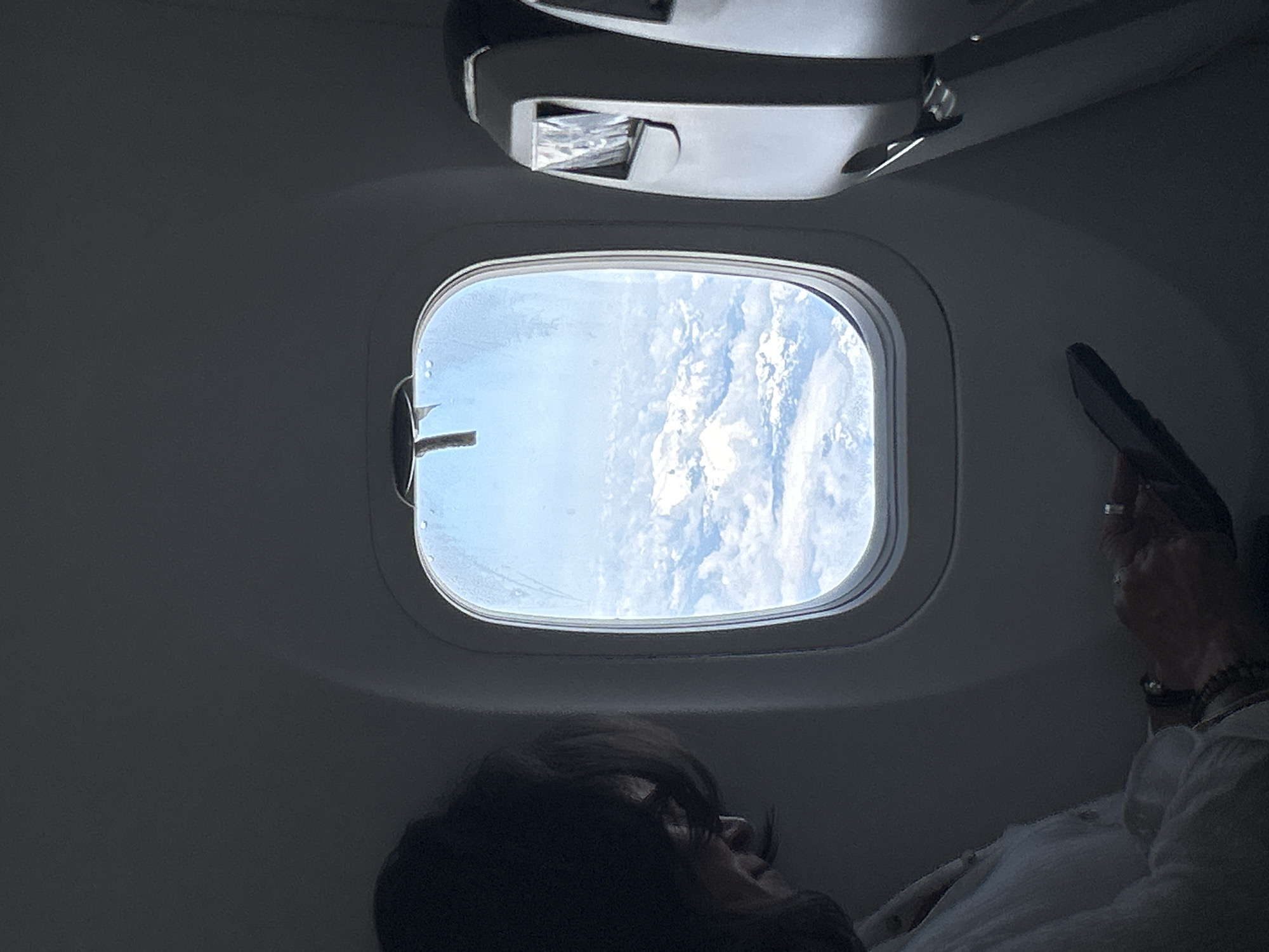 Passenger observed gazing at clouds from airplane window over Canada