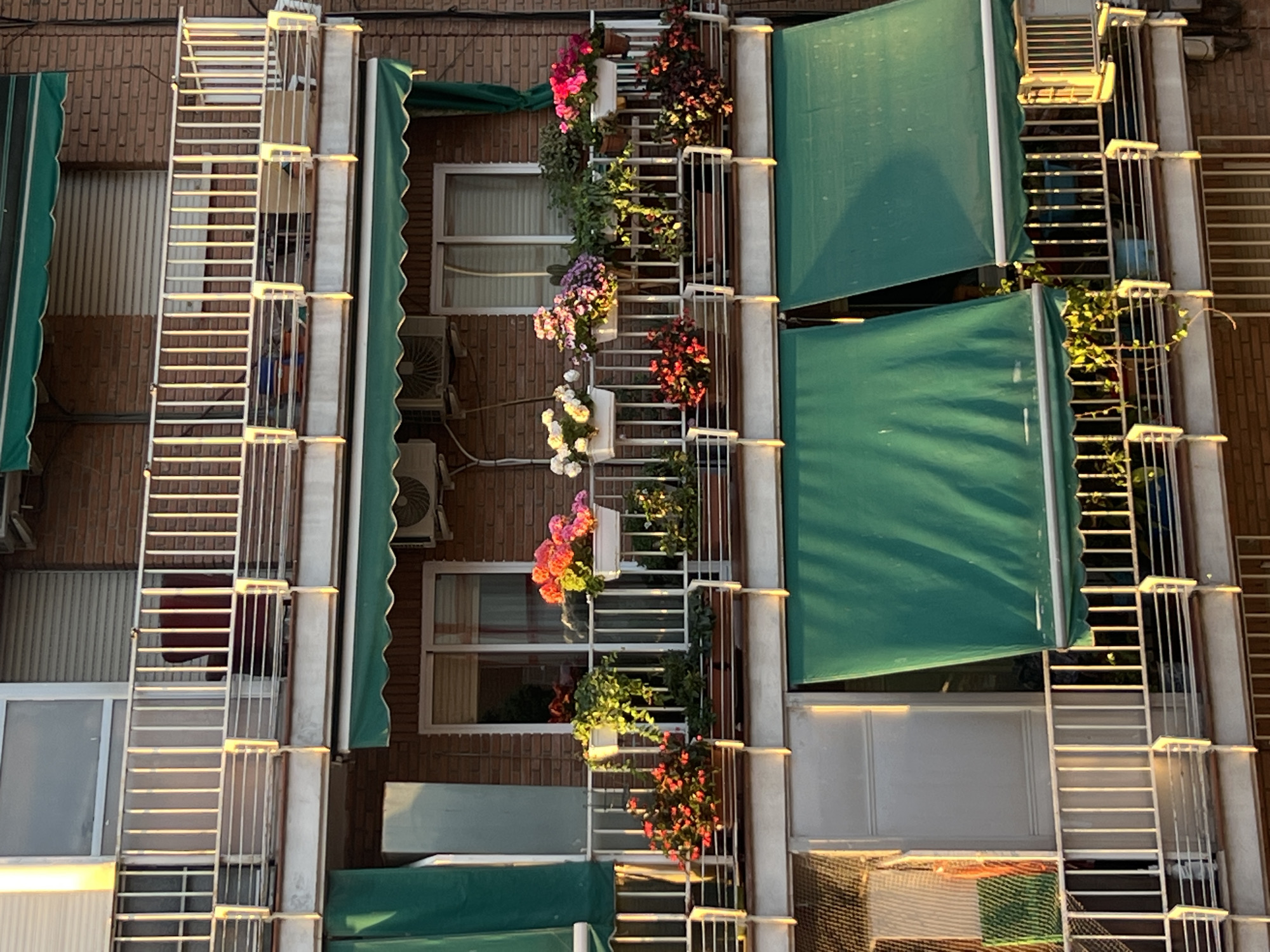 Madrid apartment building displays characteristic balcony gardens and awnings