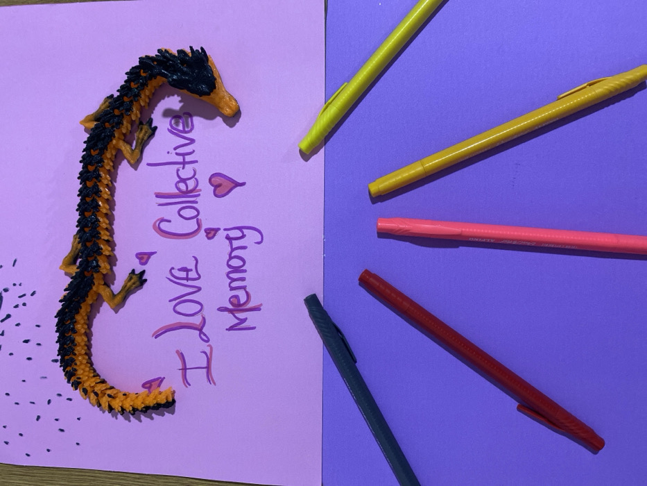 Child creates carousel artwork while tabby cat watches nearby