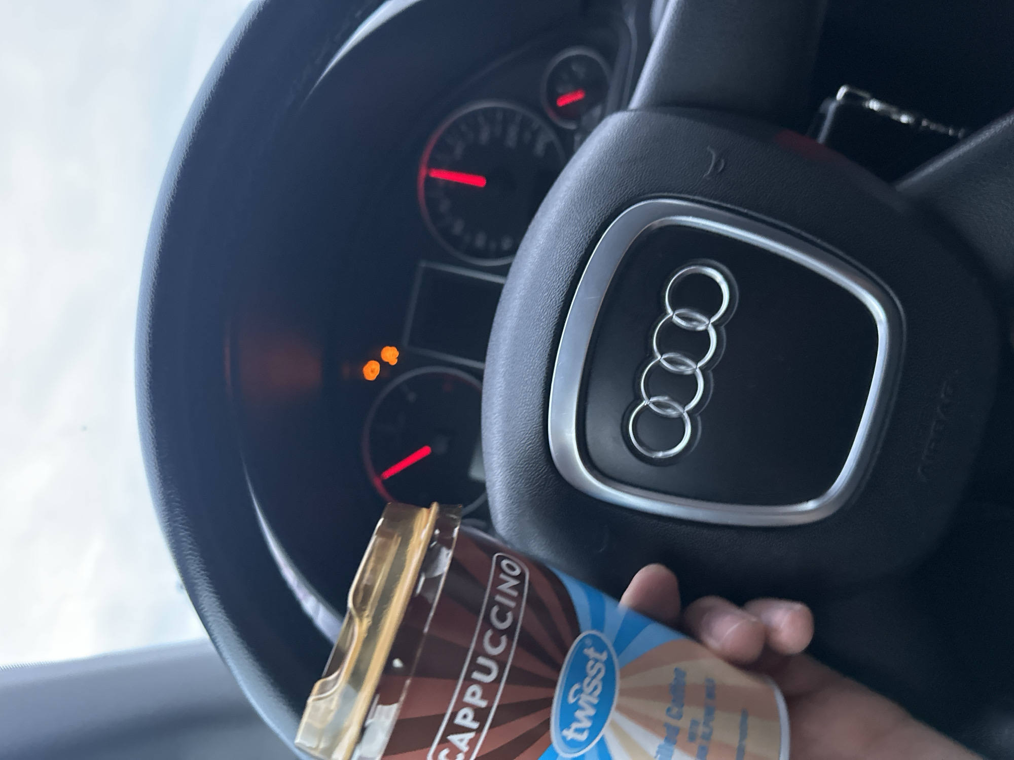 Driver holds cappuccino in Audi interior, Bulgaria