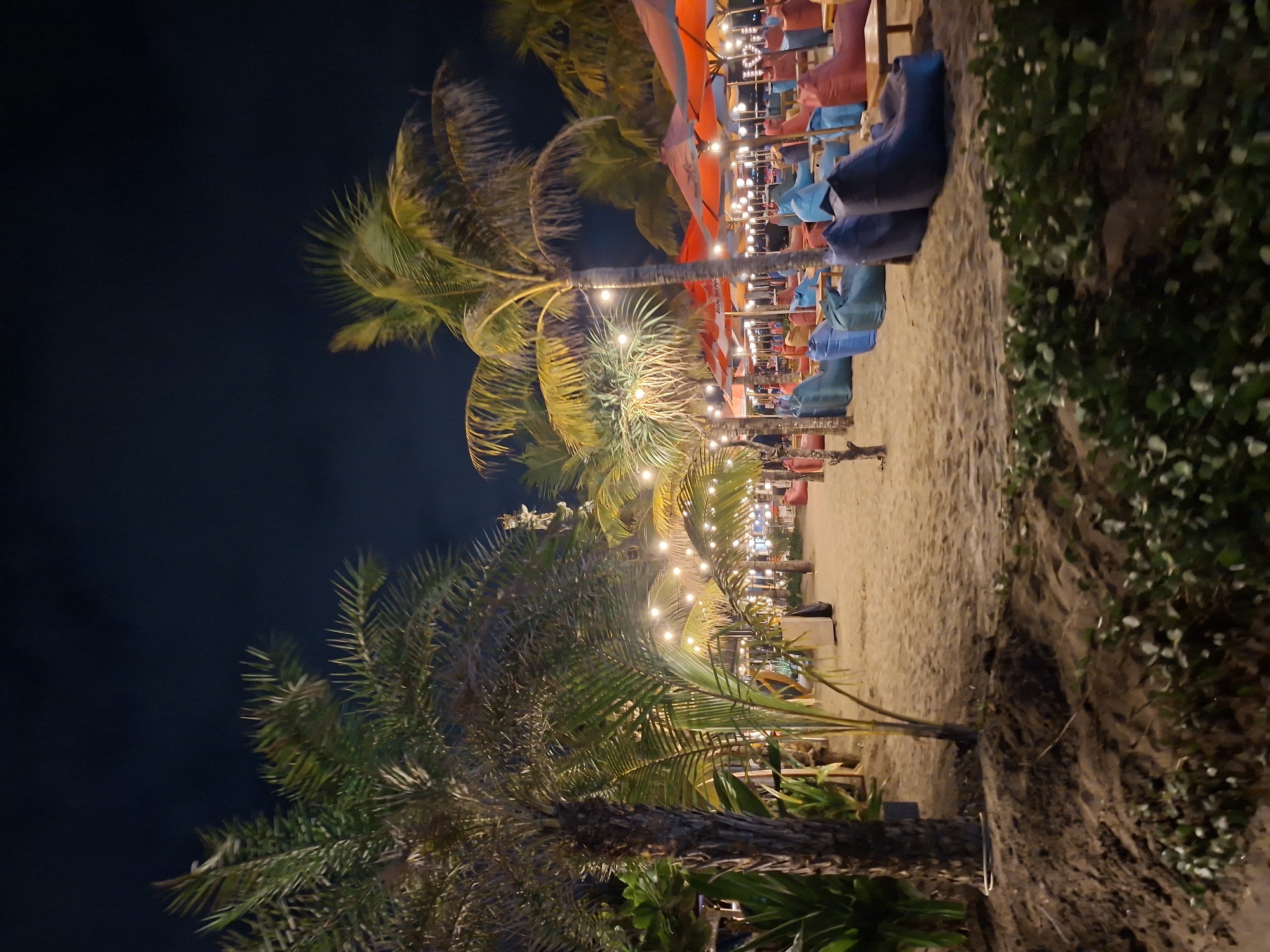 Kuta Beach bars glow at night under string lights