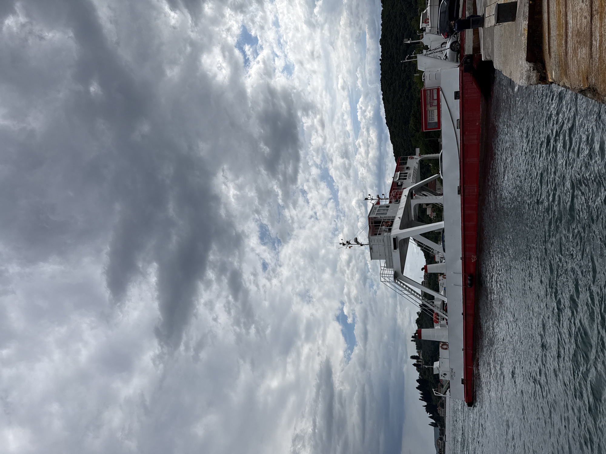 Ferry docks at Montenegro pier amid mountainous coastline
