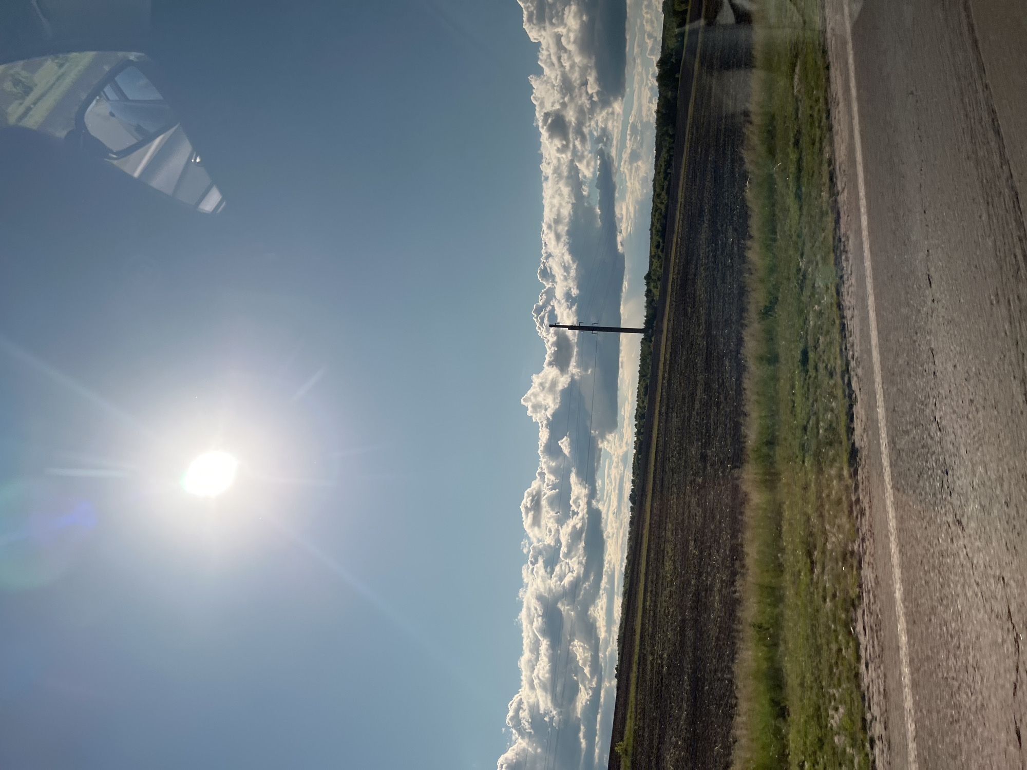 Vehicle journey through sunny rural countryside documented Friday afternoon