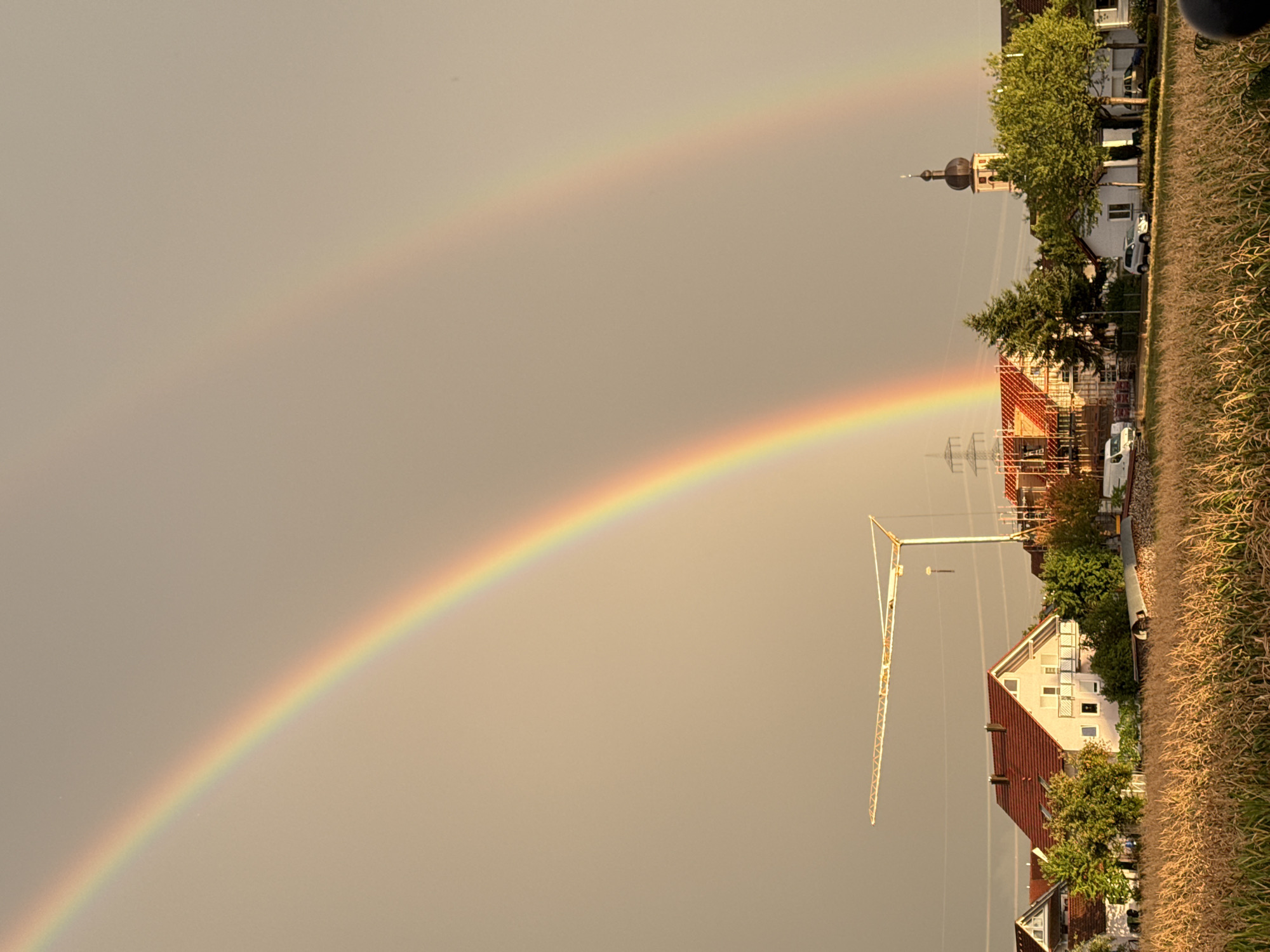 Double rainbow over dry cornfields in rural Germany