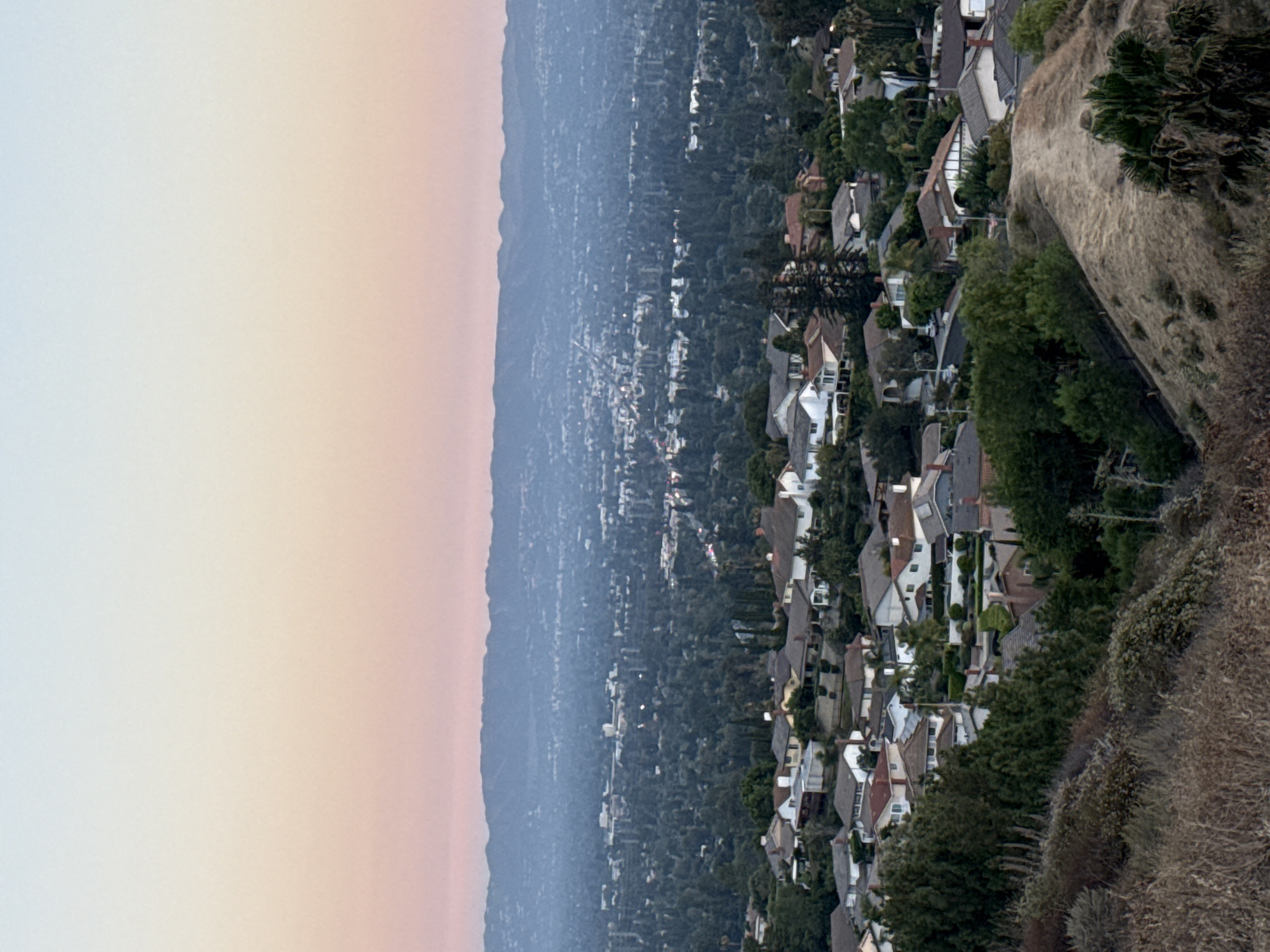 LA hillside neighborhood glows under a fading dusk sky