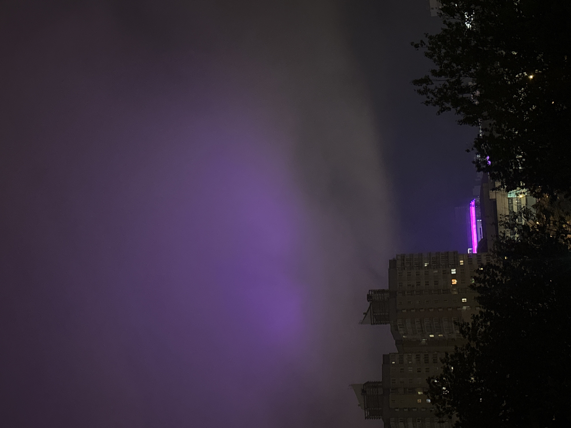 Foggy night illuminates purple-lit building in Minsk