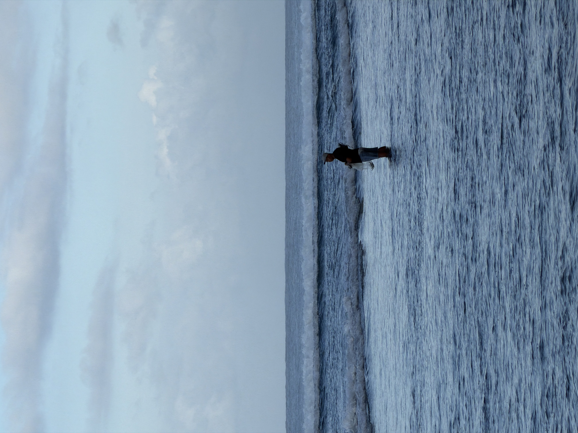Person explores rocky coastline during low tide in Kuta Selatan