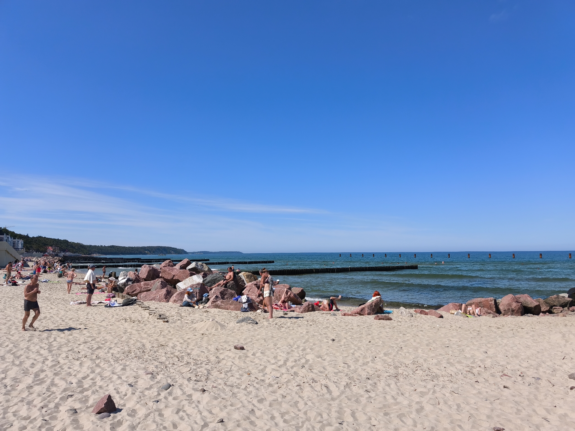 Crowded Svetlogorsk beach hosts swimmers and a working excavator