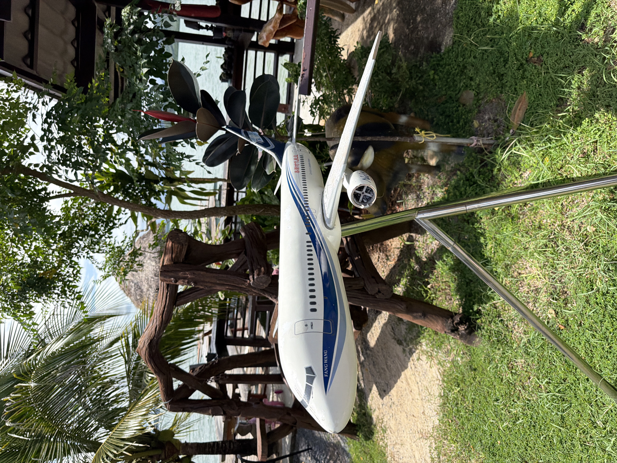 Lakeside resort with pier, model plane, and tropical details