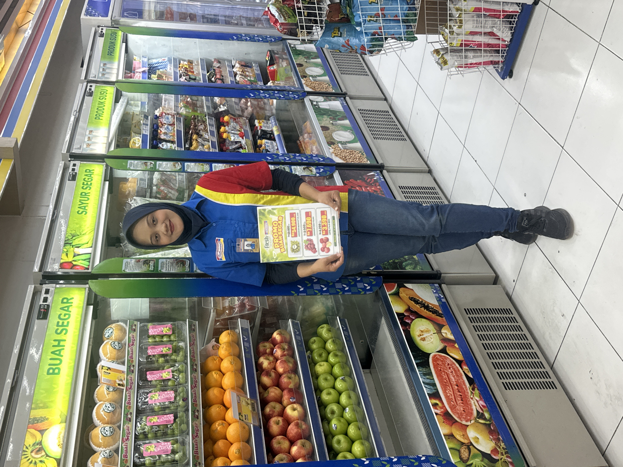 Convenience store worker near fresh produce fridge in North Kuta
