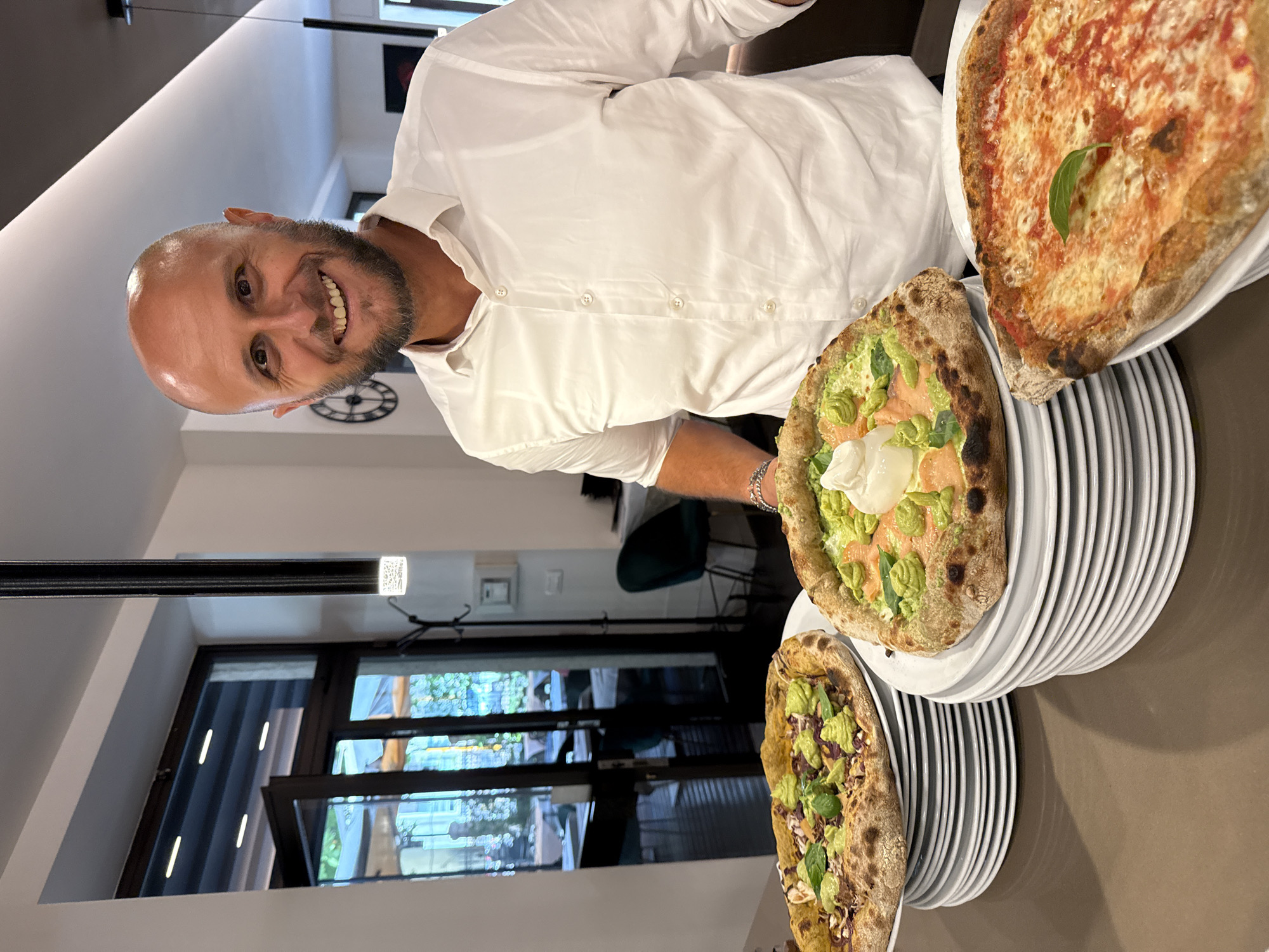Fresh Neapolitan pizzas coming out of a dome oven in Trento