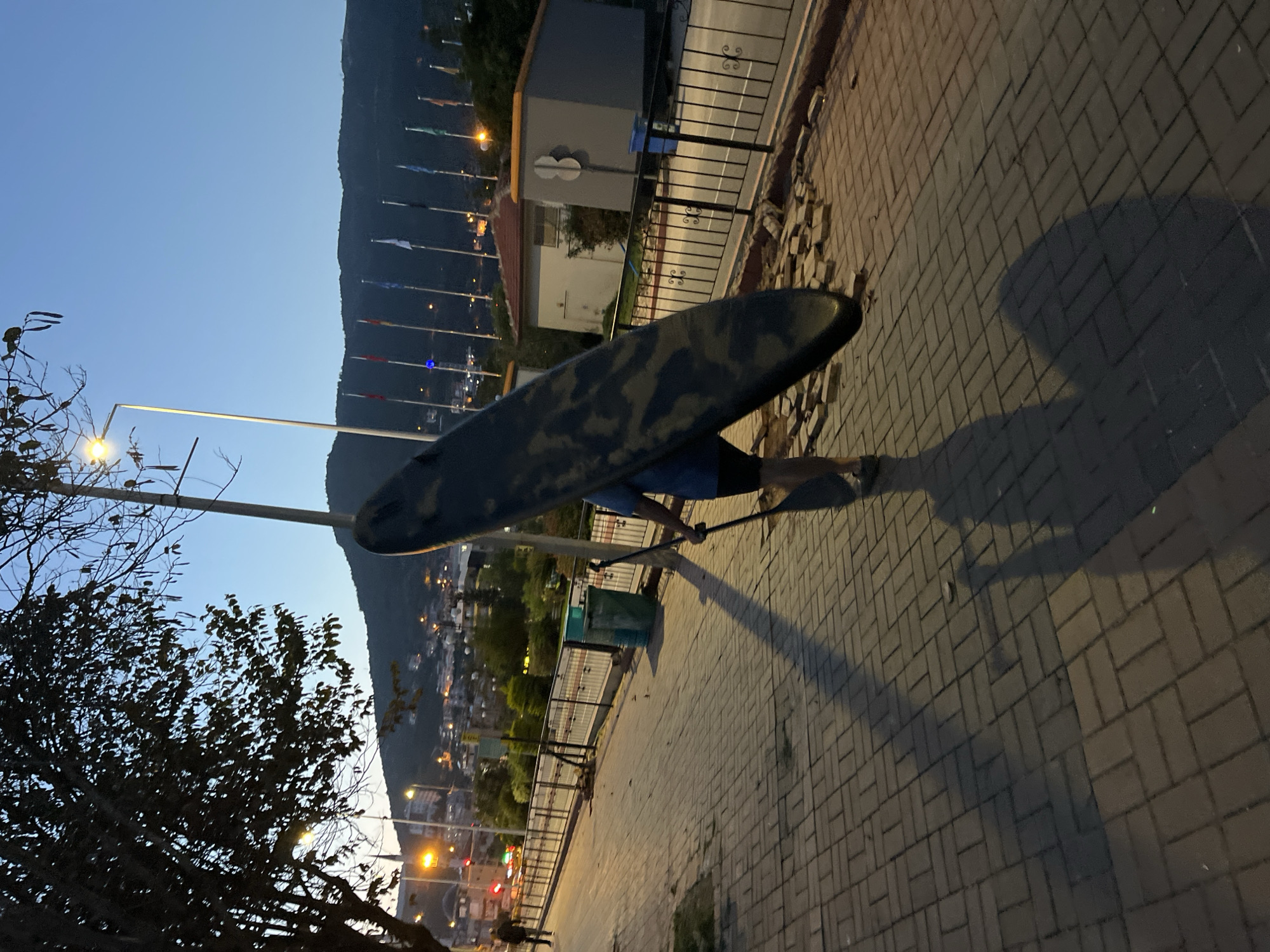 Person carries paddleboard through Alanya streets