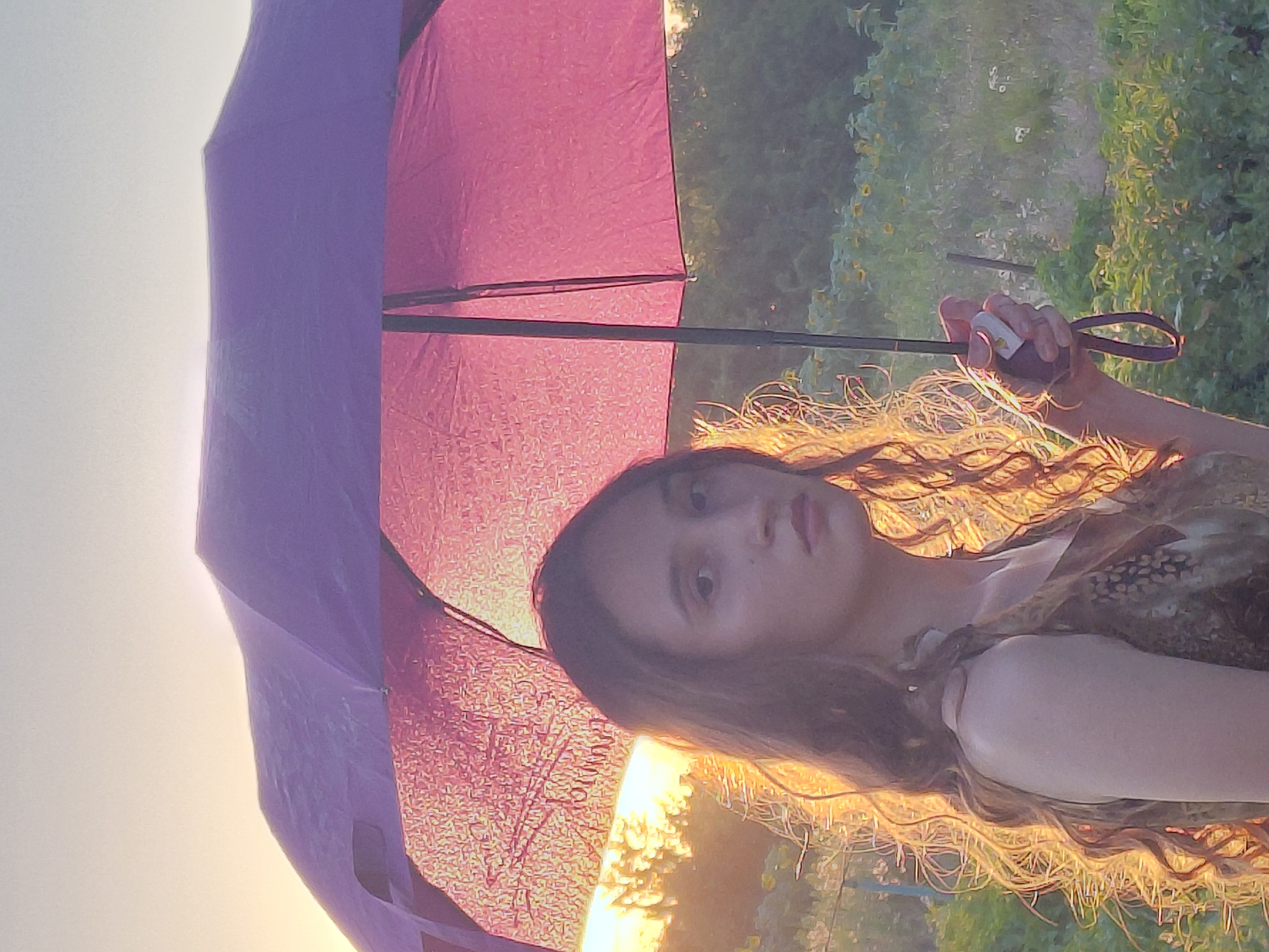 Golden hour umbrella portraits in an open field at sunset